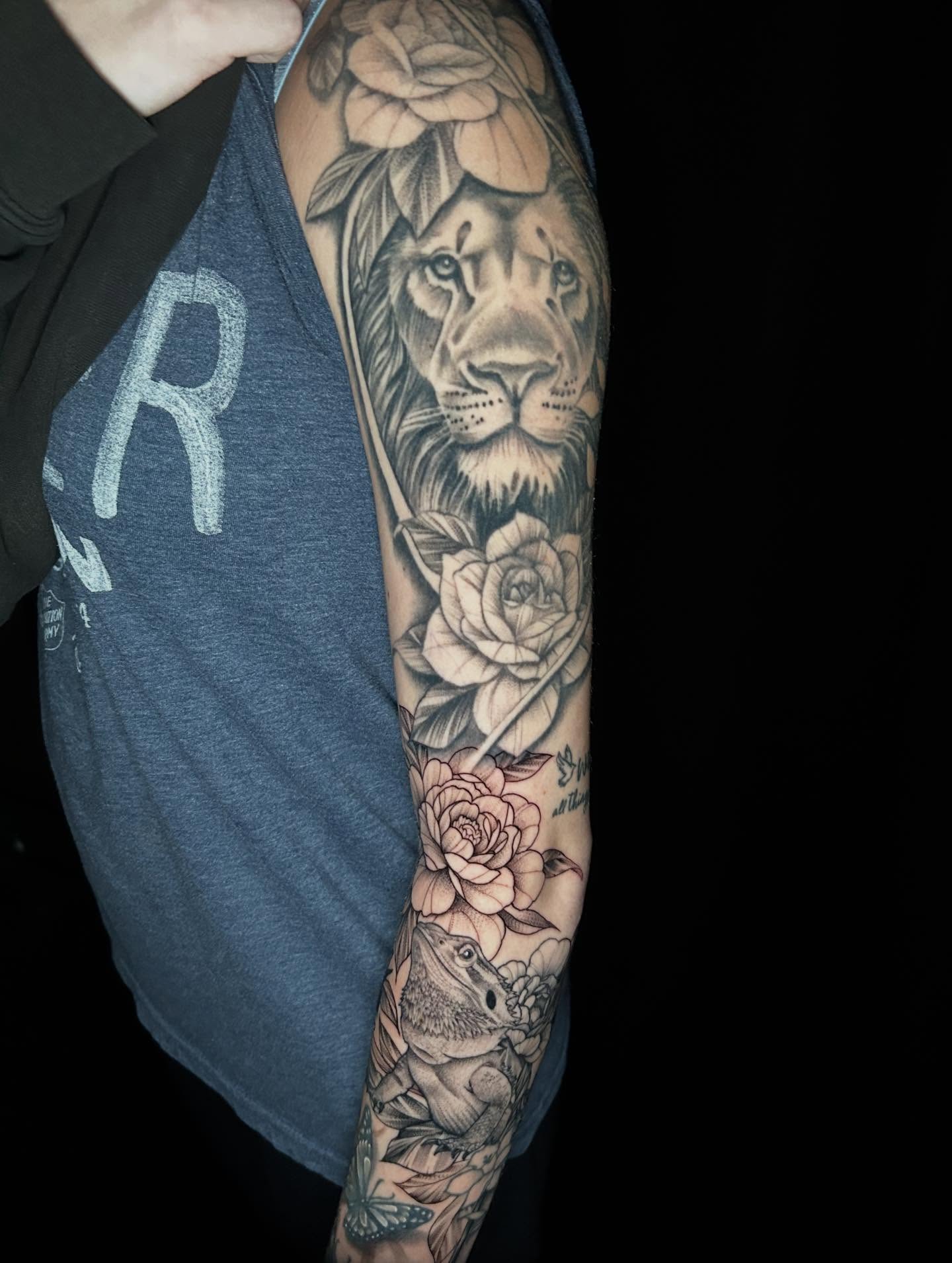 Lion and roses black and grey tattoo on the forearm by Mayhem Andrews