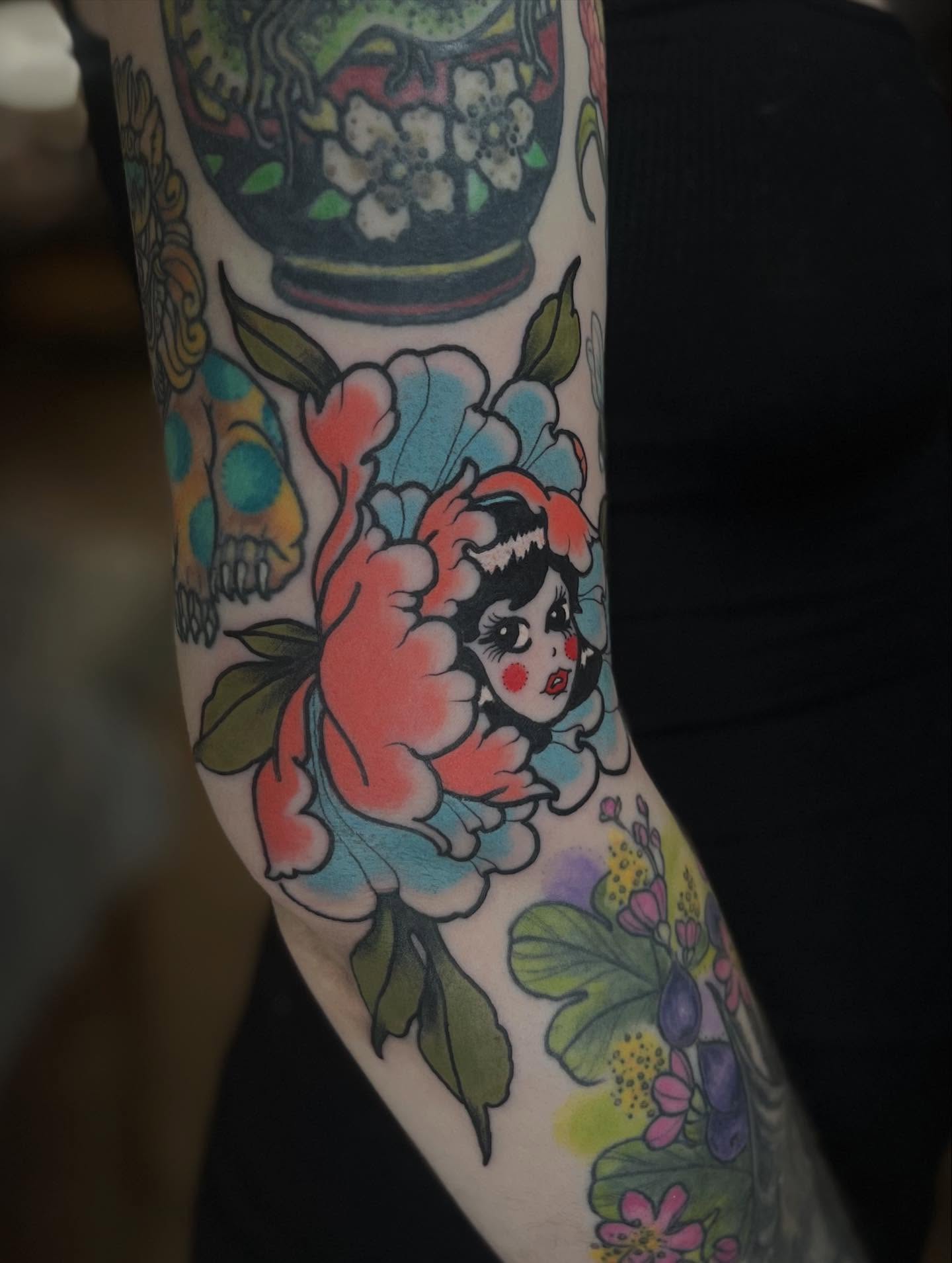 Peony and cherub American traditional tattoo on the forearm by Kaichi Fujita, Eugene, Oregon