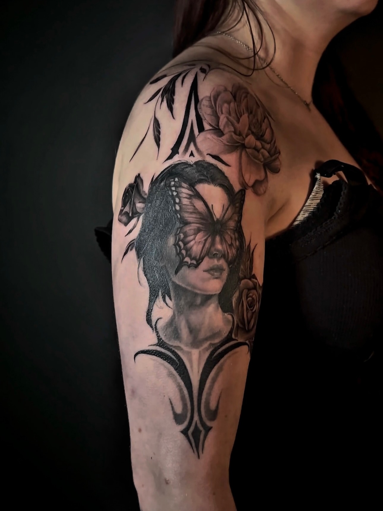 Woman with butterfly realism tattoo on the upper arm by Sincere