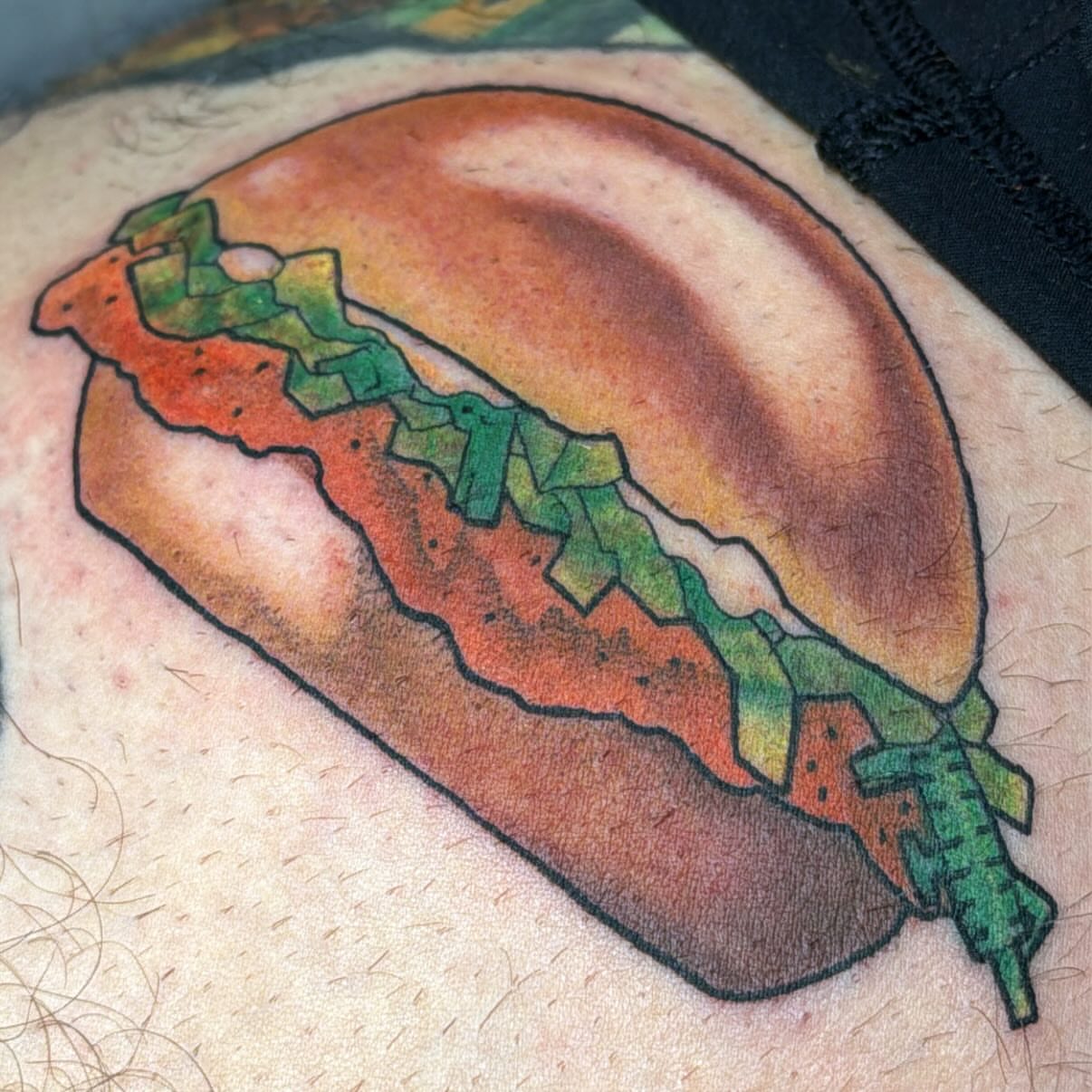 Hot dog realism tattoo on the upper arm by Eli