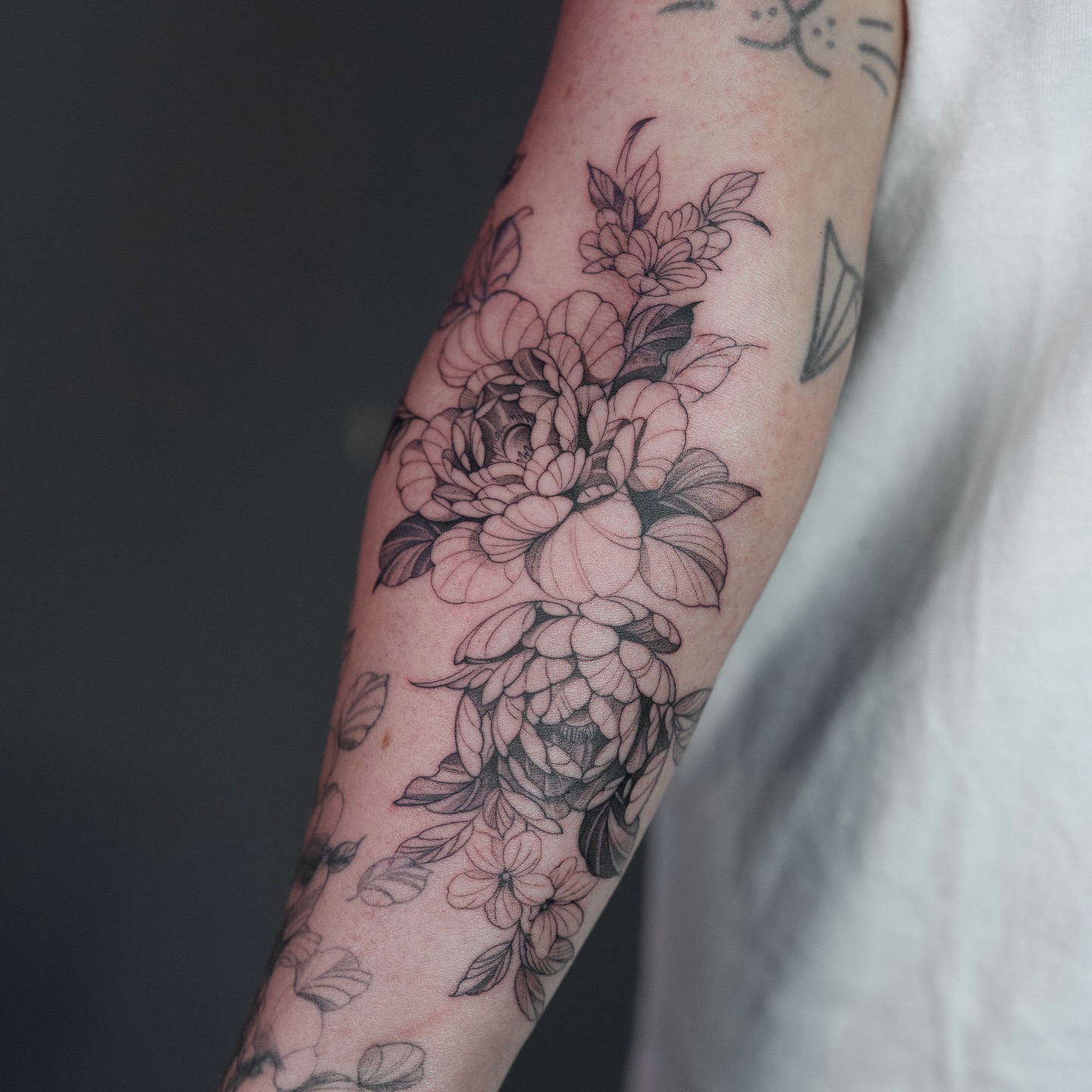 Floral bouquet black and grey tattoo on the forearm by B o n d B o n d , “ a r t i s t “