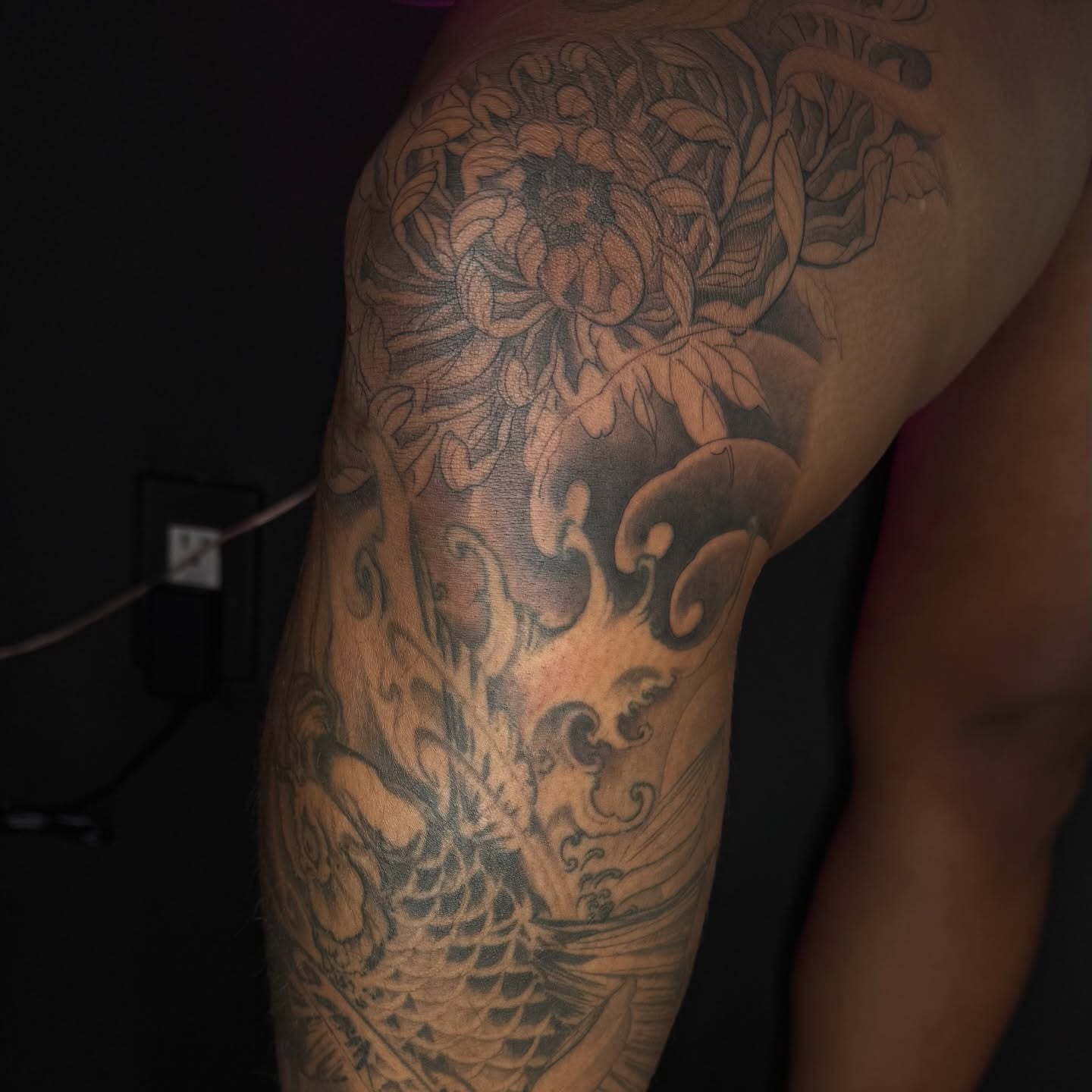 Koi fish and floral japanese irezumi tattoo on the upper arm by B o n d B o n d , “ a r t i s t “