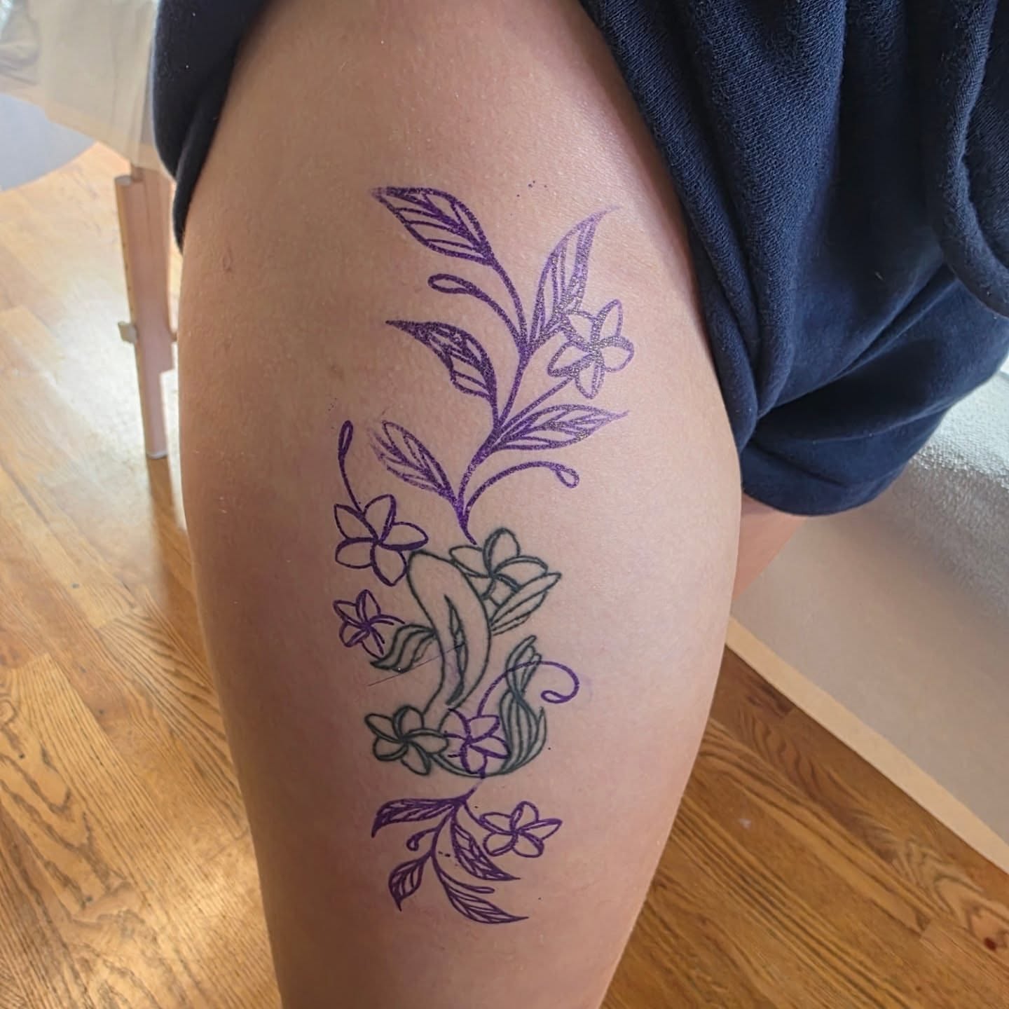 Floral arrangement fine line tattoo on the thigh by Tattoos by Annie