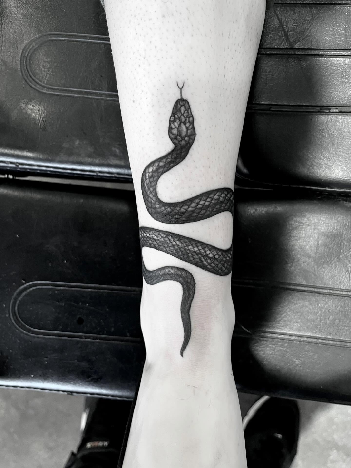Snake black and grey tattoo on the forearm by Nathan Esteras