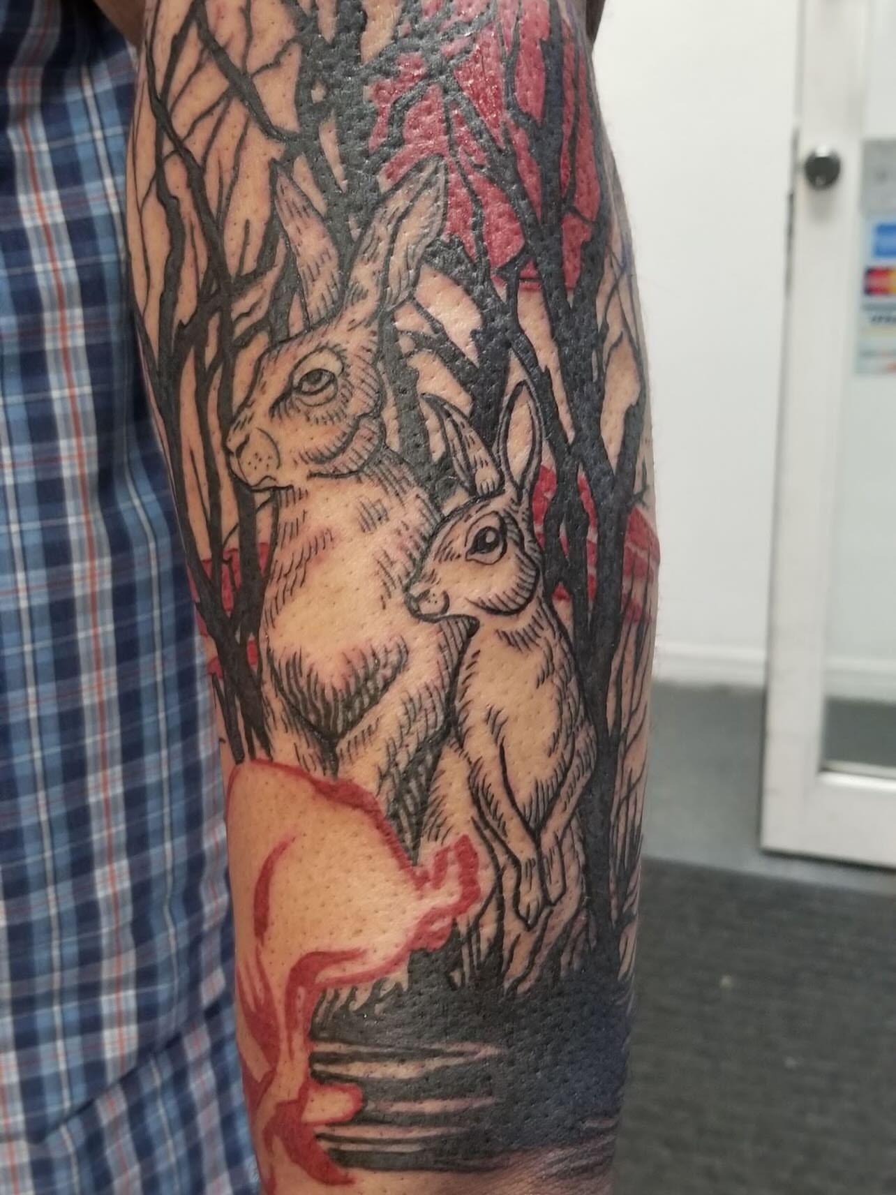 Hares in forest realism tattoo on the forearm by Jason Middelton
