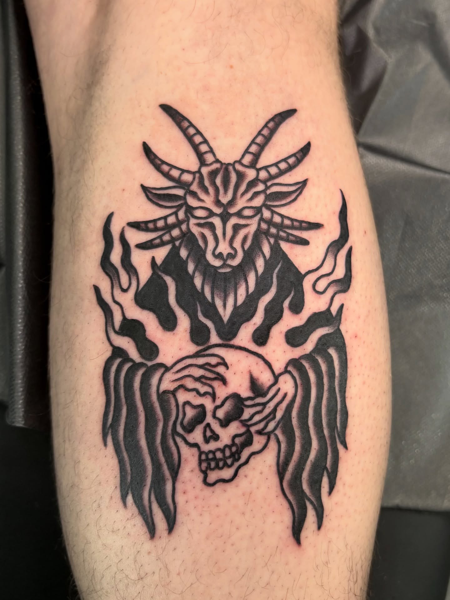 Goat skull and flame black and grey tattoo on the forearm by Jamie Yuu, Minneapolis, Minnesota