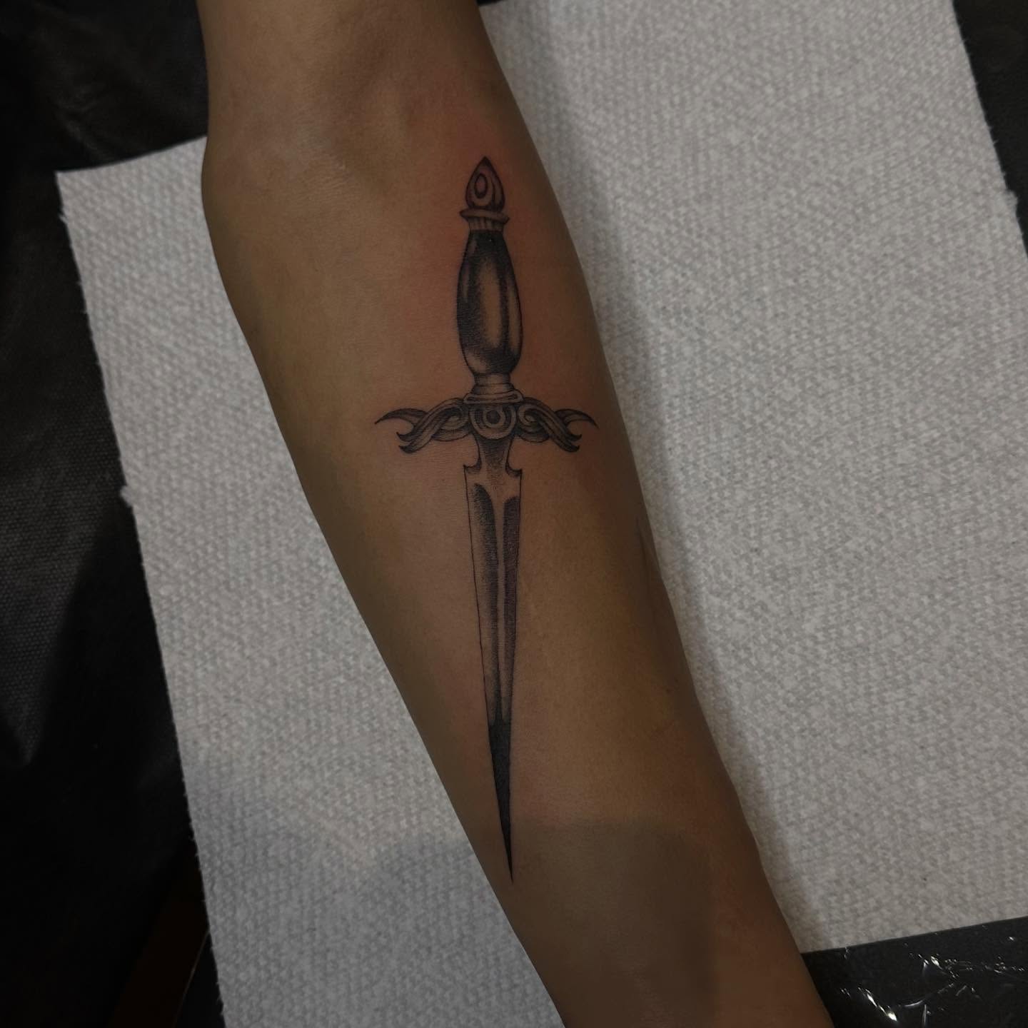 Sword black and grey tattoo on the forearm by 𝖍𝖆𝖓𝖓𝖆𝖍
