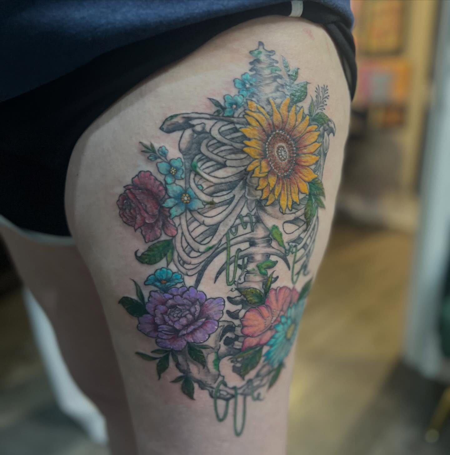 Skeleton with flowers new school tattoo on the thigh by Rikki