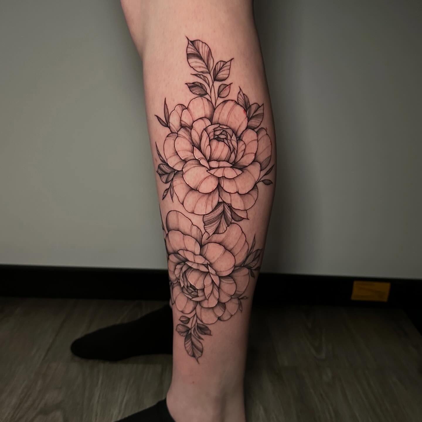 Peony flowers black and grey tattoo on the calf by Megan McKee Tattoo Artist