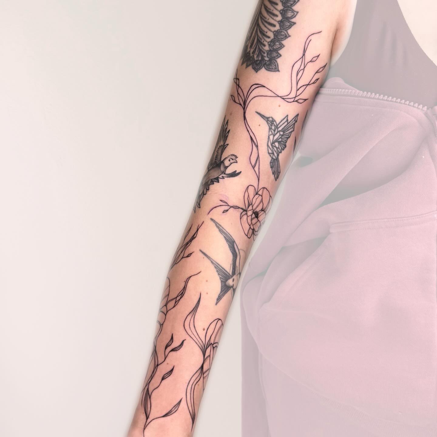 Birds and flowers black and grey tattoo on the forearm by Nika