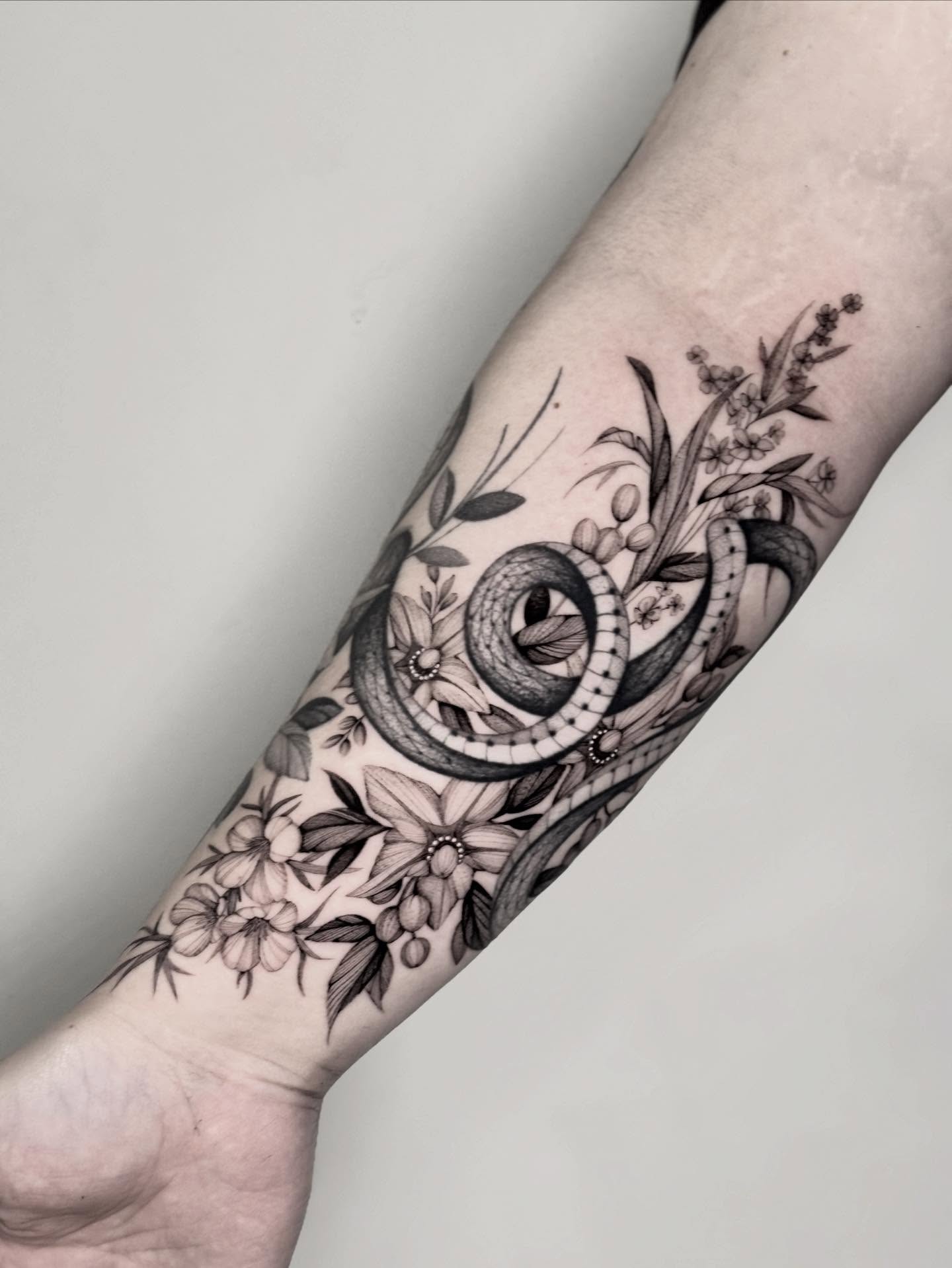 Snake and floral dotwork tattoo on the forearm by Brittney Naami, San Francisco, California