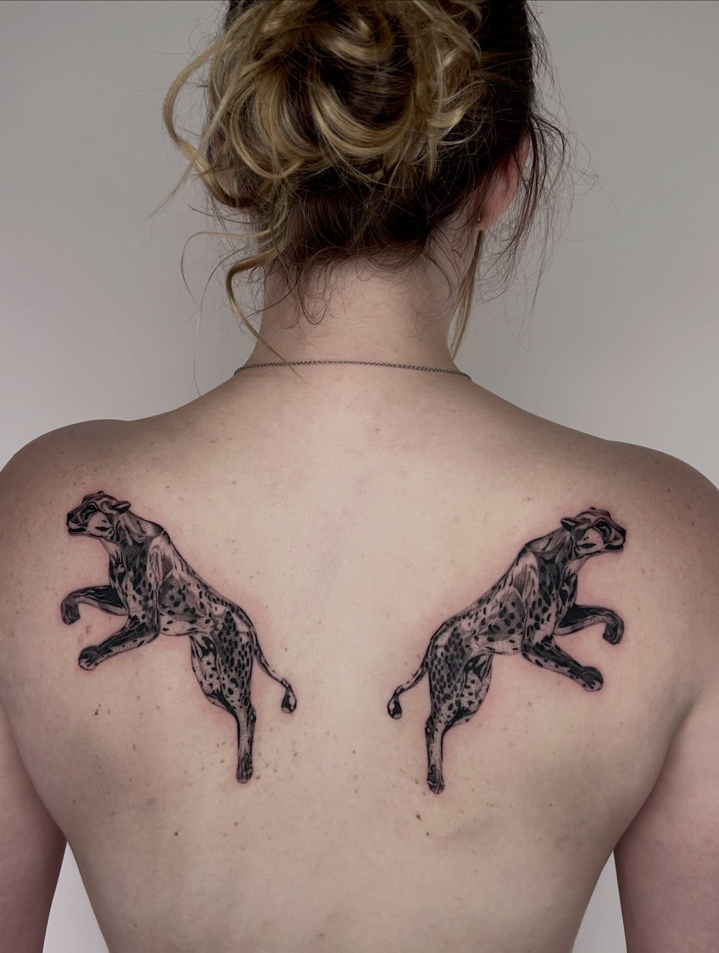 Leopards black and grey tattoo on the back by Kennedy Ramey