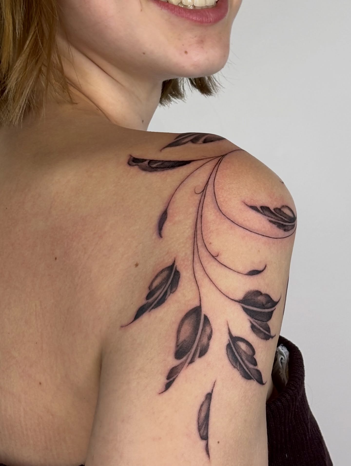 Feather black and grey tattoo on the shoulder by Dani