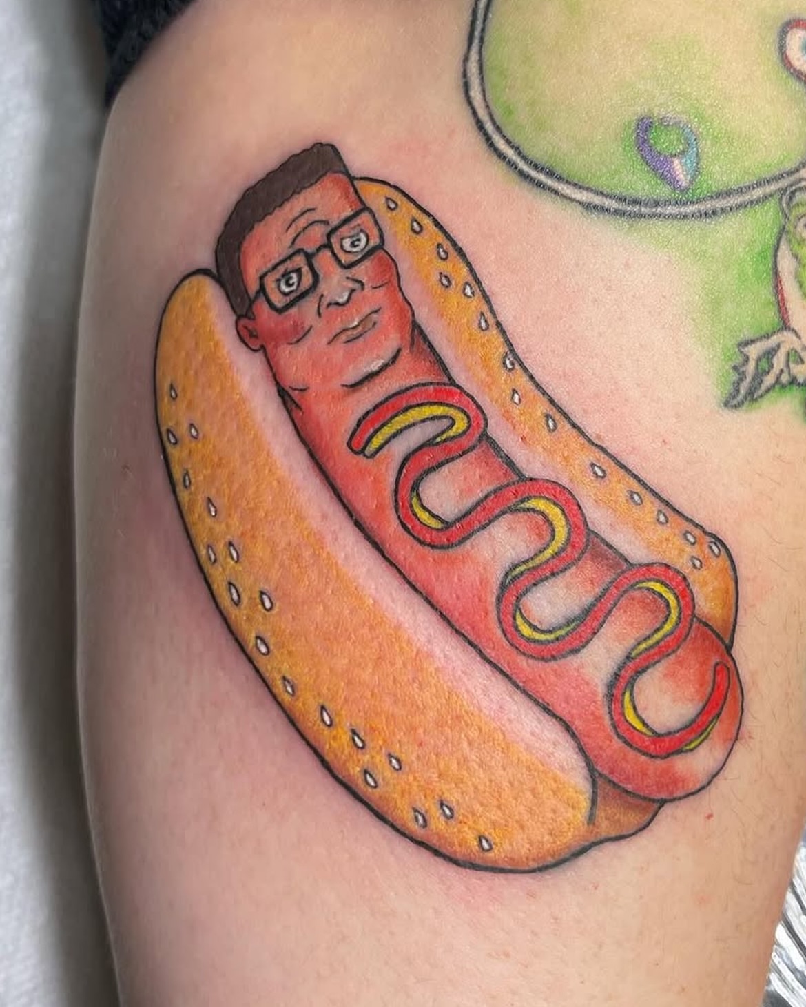 Hot dog dotwork tattoo on the upper arm by Rachel Hanke