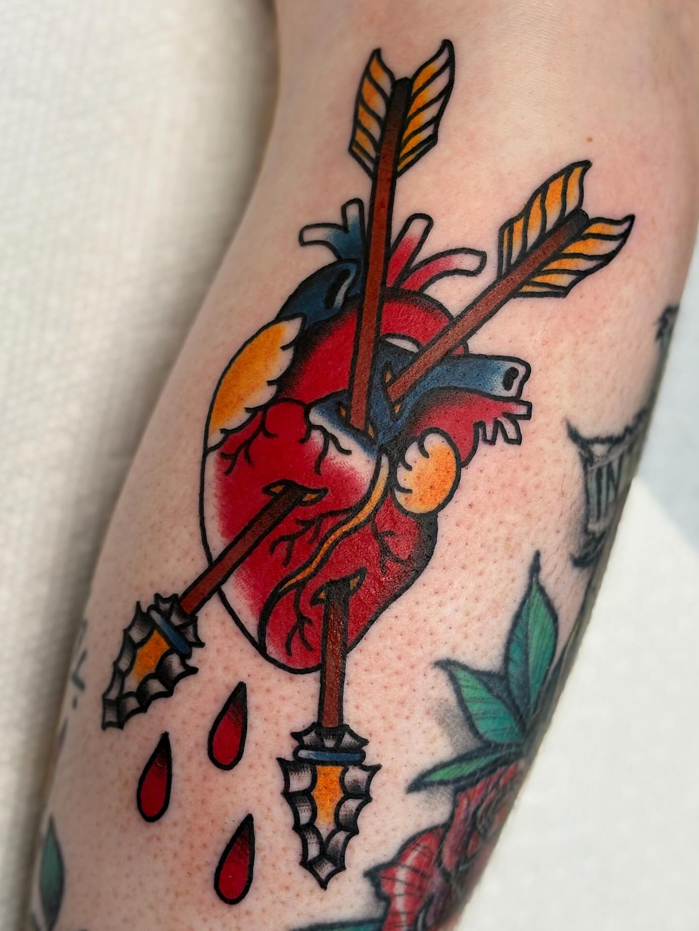 Heart pierced by arrows American traditional tattoo on the forearm by Dakota Amato