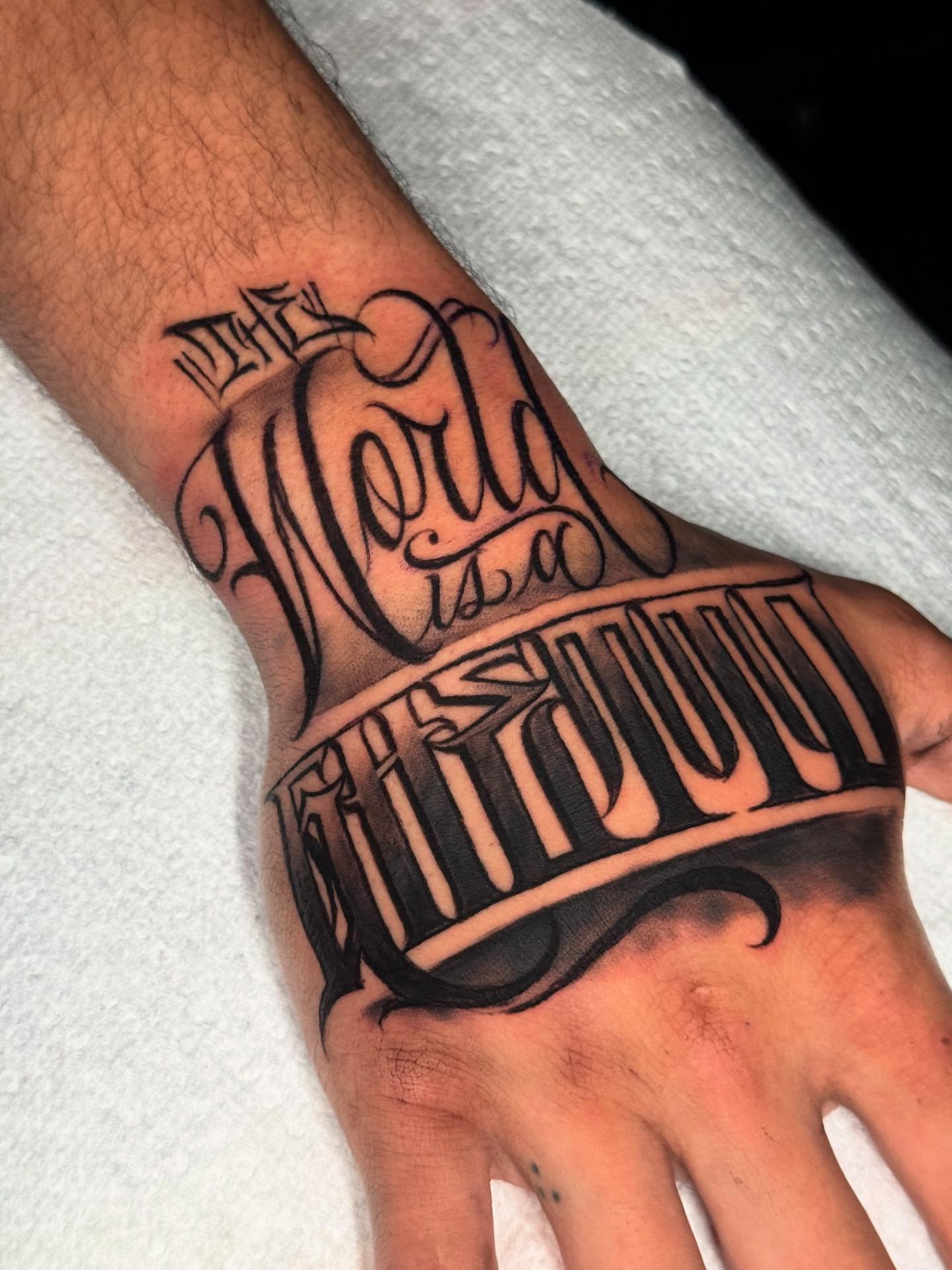 The World Is A Beautiful Place lettering script tattoo on the hand by 𝕾𝖈𝖗𝖎𝖕𝖙 𝕾𝖕𝖊𝖈𝖎𝖆𝖑𝖎𝖘𝖙