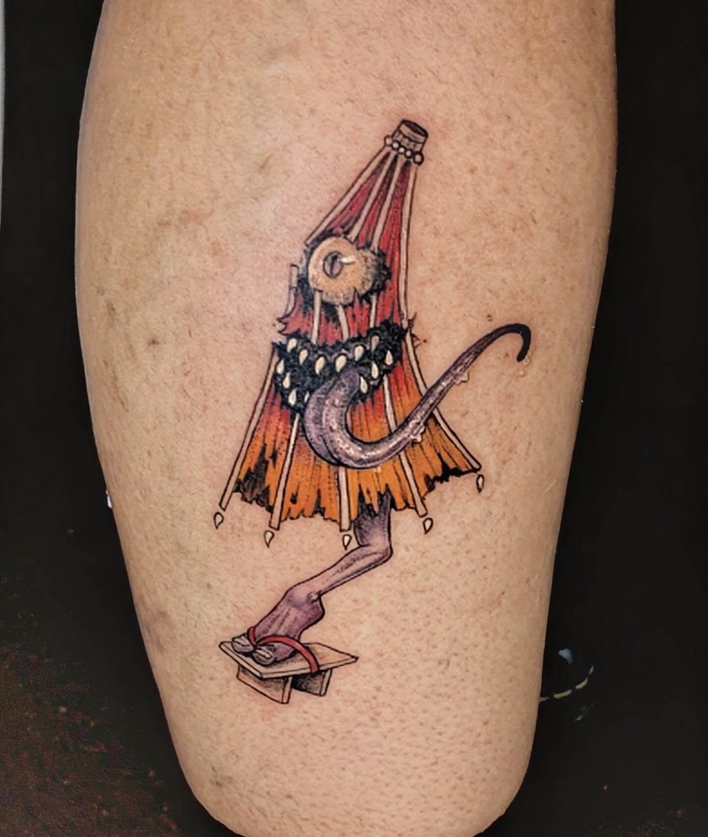 Snake and mask illustrative tattoo on the thigh by Shannon