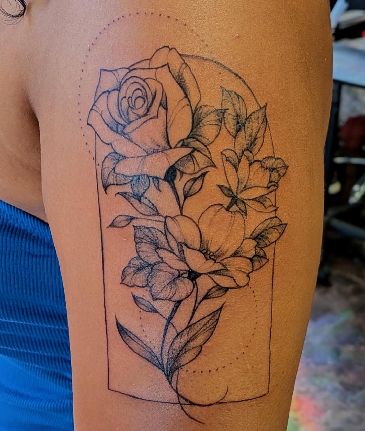 Flowers in vase black and grey tattoo on the upper arm by Shannon