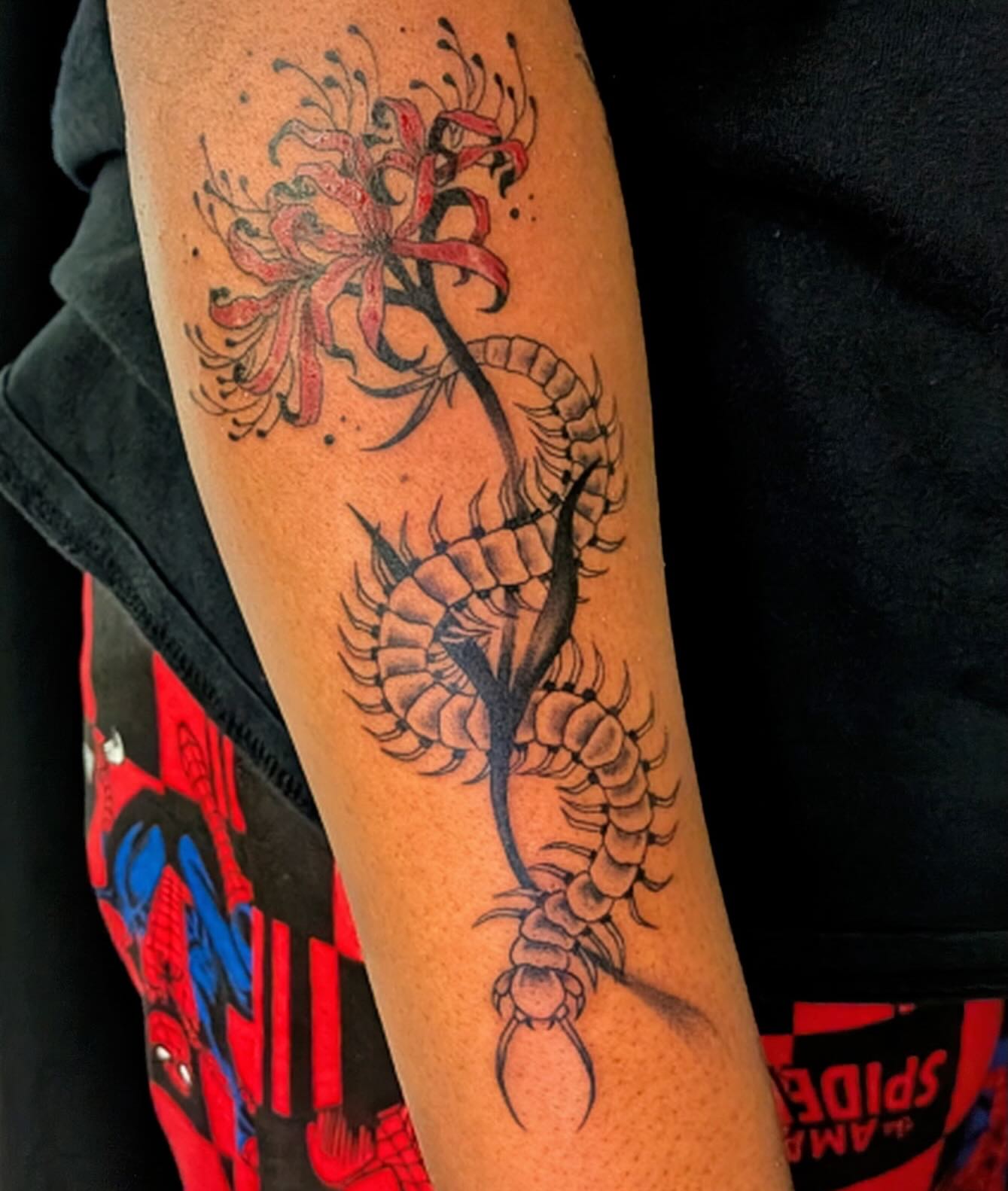 Centipede and flower black and grey tattoo on the forearm by Shannon