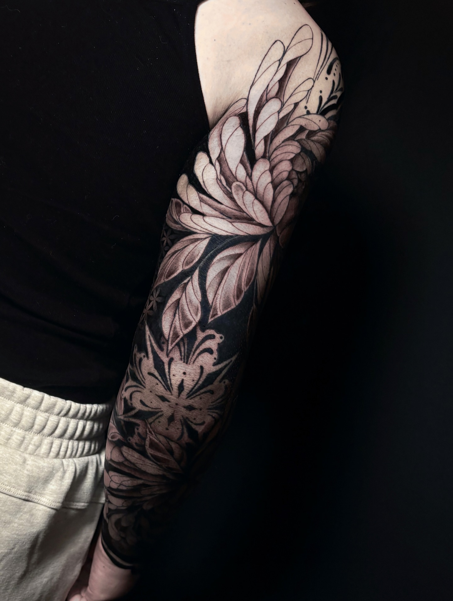 Floral design black and grey tattoo on the forearm by Fine Line Tattoo Artist