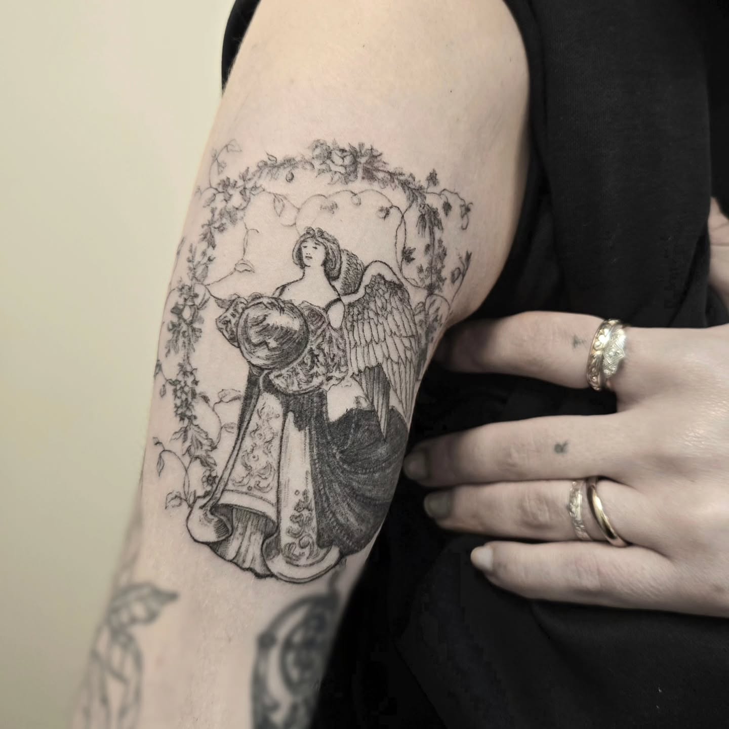 Angel with shield realism tattoo on the upper arm by Vintage tattoo