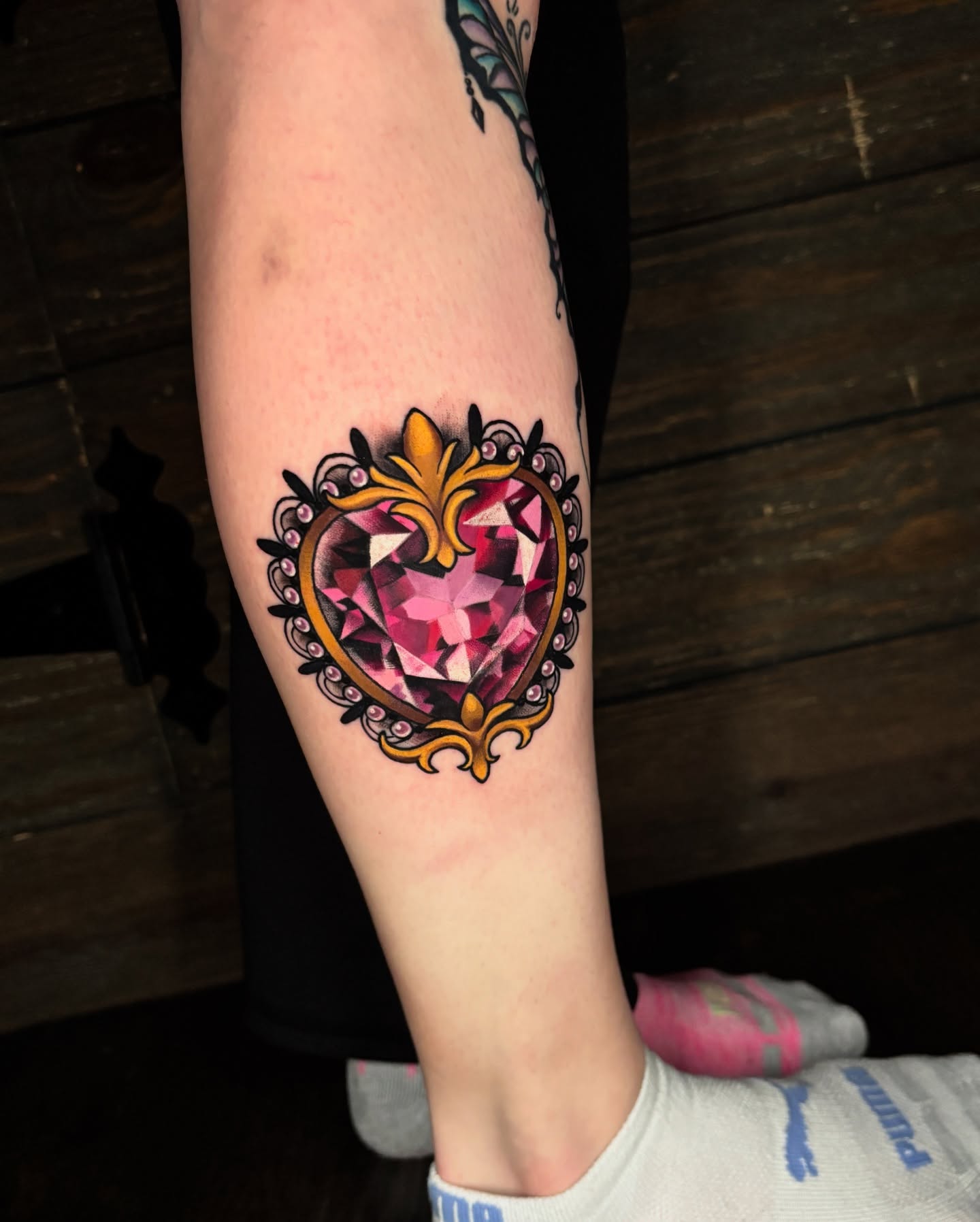 Gemstone heart geometric tattoo on the forearm by Latesha Burnley
