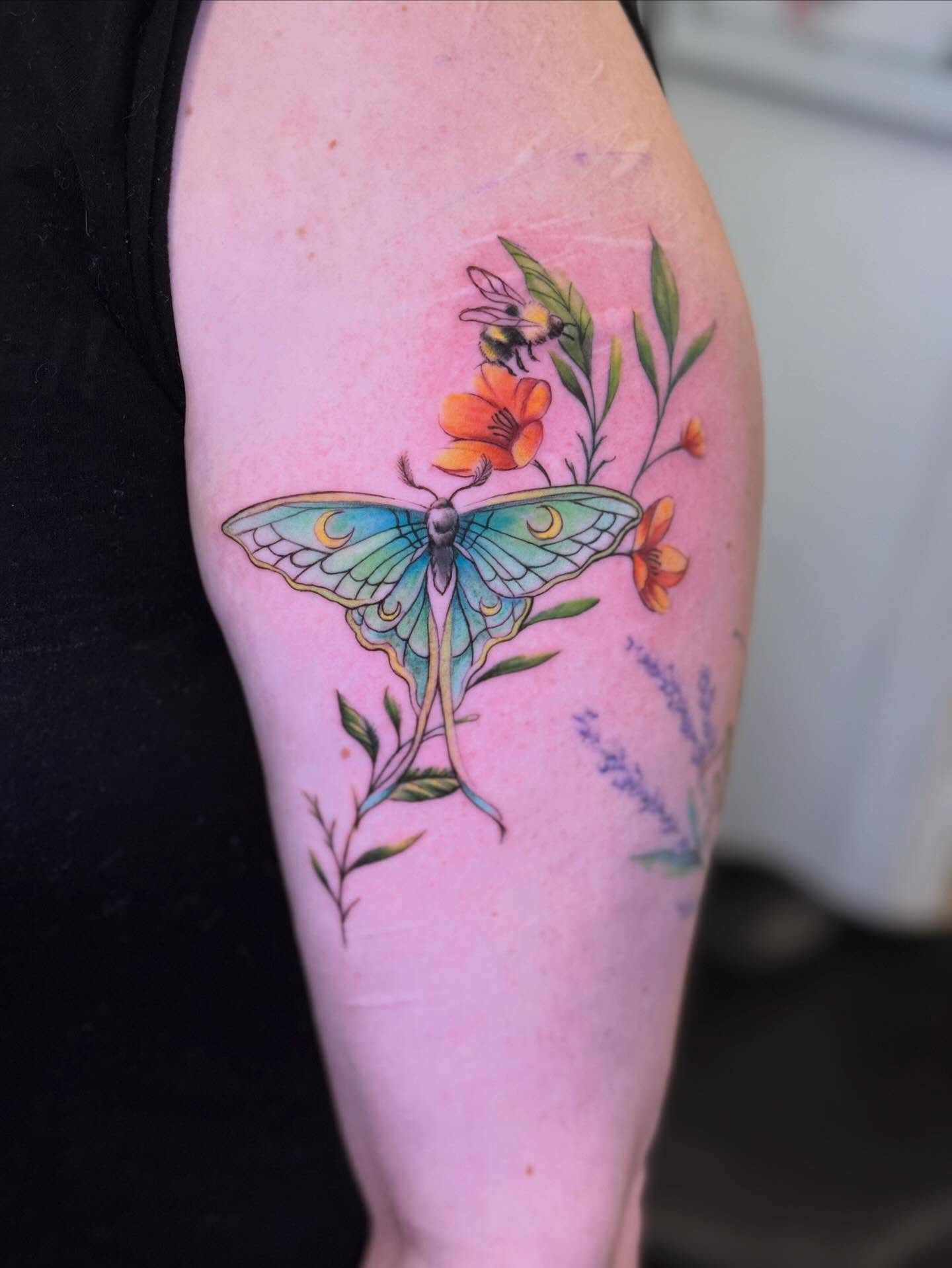 Butterfly and flowers watercolor tattoo on the forearm by Vega