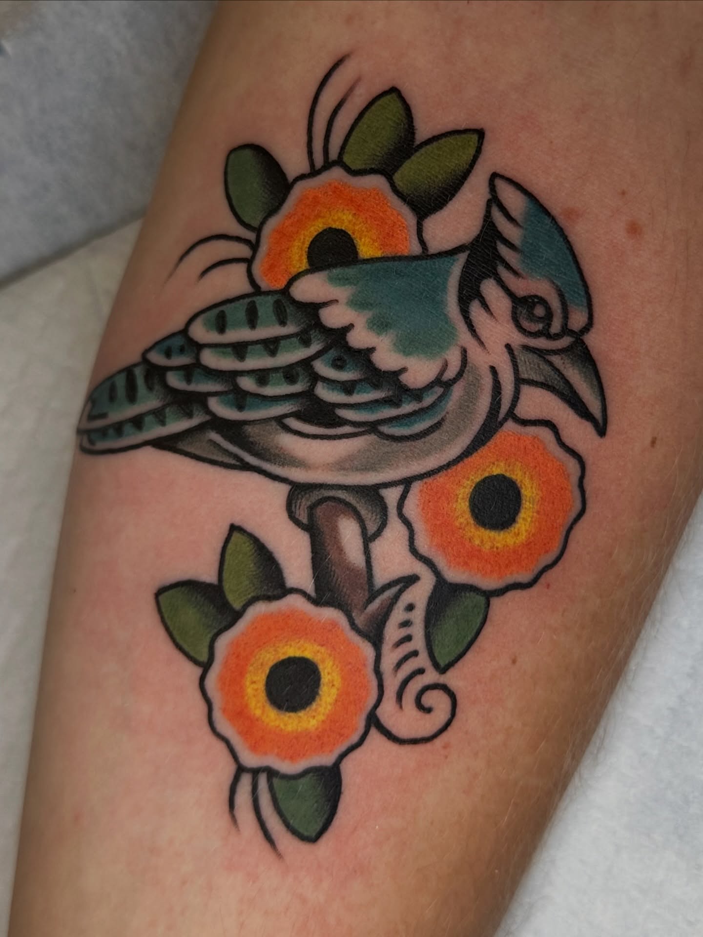 Bird and flowers American traditional tattoo on the forearm by Kevin R. Onley