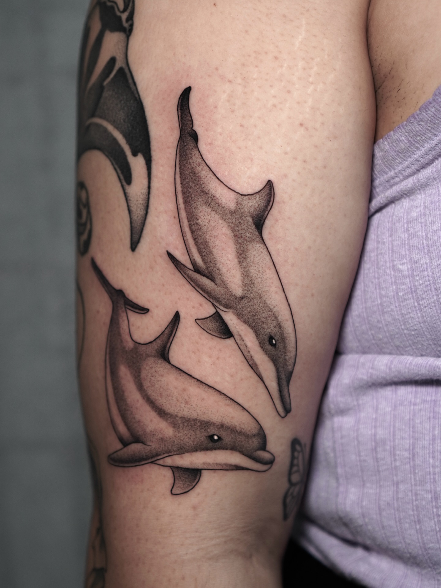 Dolphins dotwork tattoo on the forearm by Carlos Abad