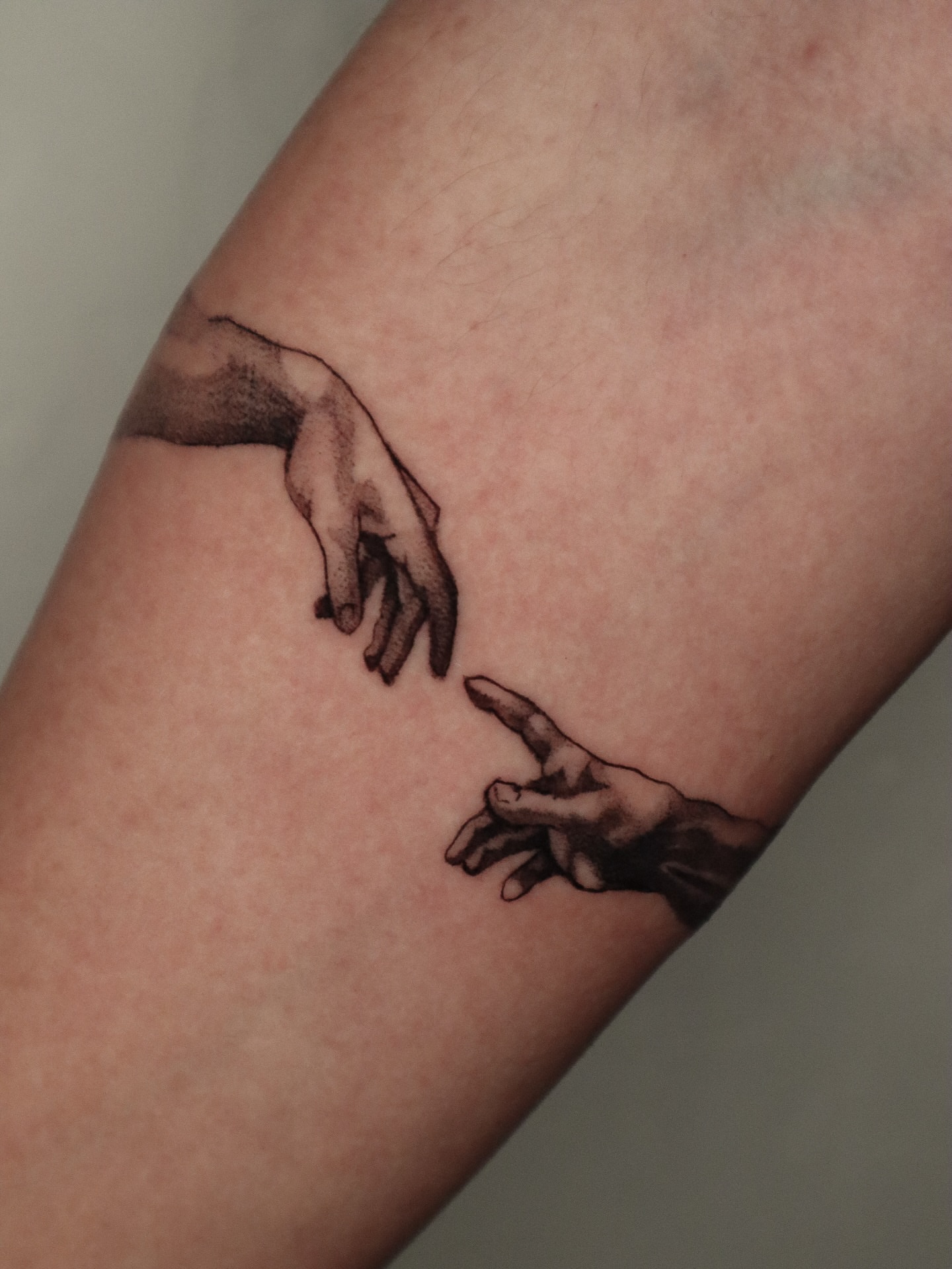 Hands reaching black and grey tattoo on the forearm by 𝕮𝖔𝖓𝖓𝖔𝖗 ☾  ~ TATTOO ARTIST