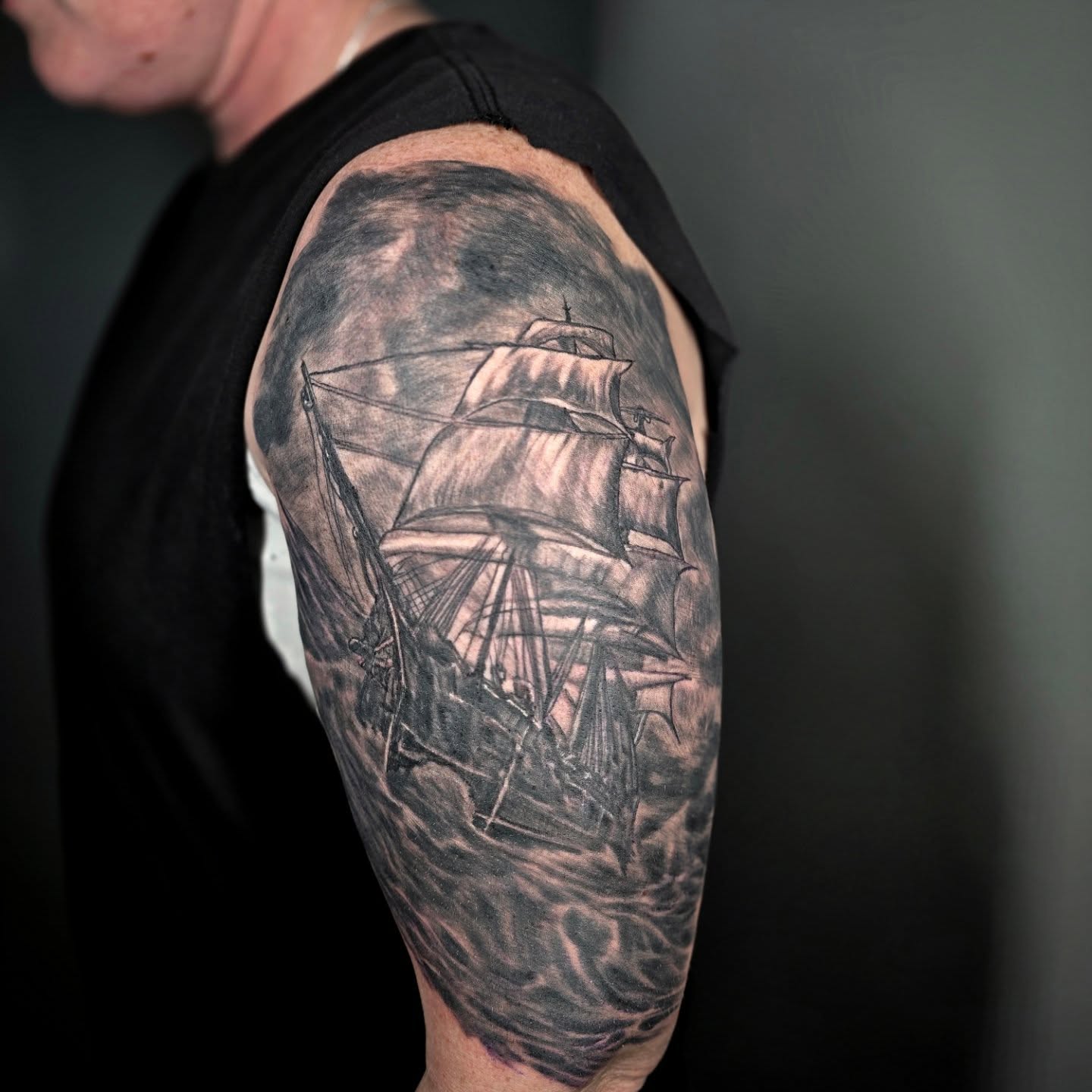 Ship sailing through storm realism tattoo on the upper arm by Karen Cain