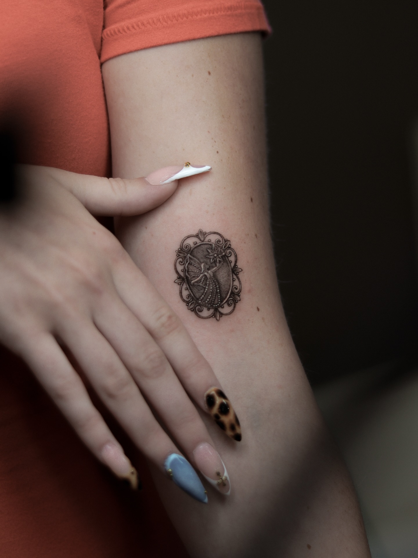 Woman in dress black and grey tattoo on the forearm by Arthur Kossoski