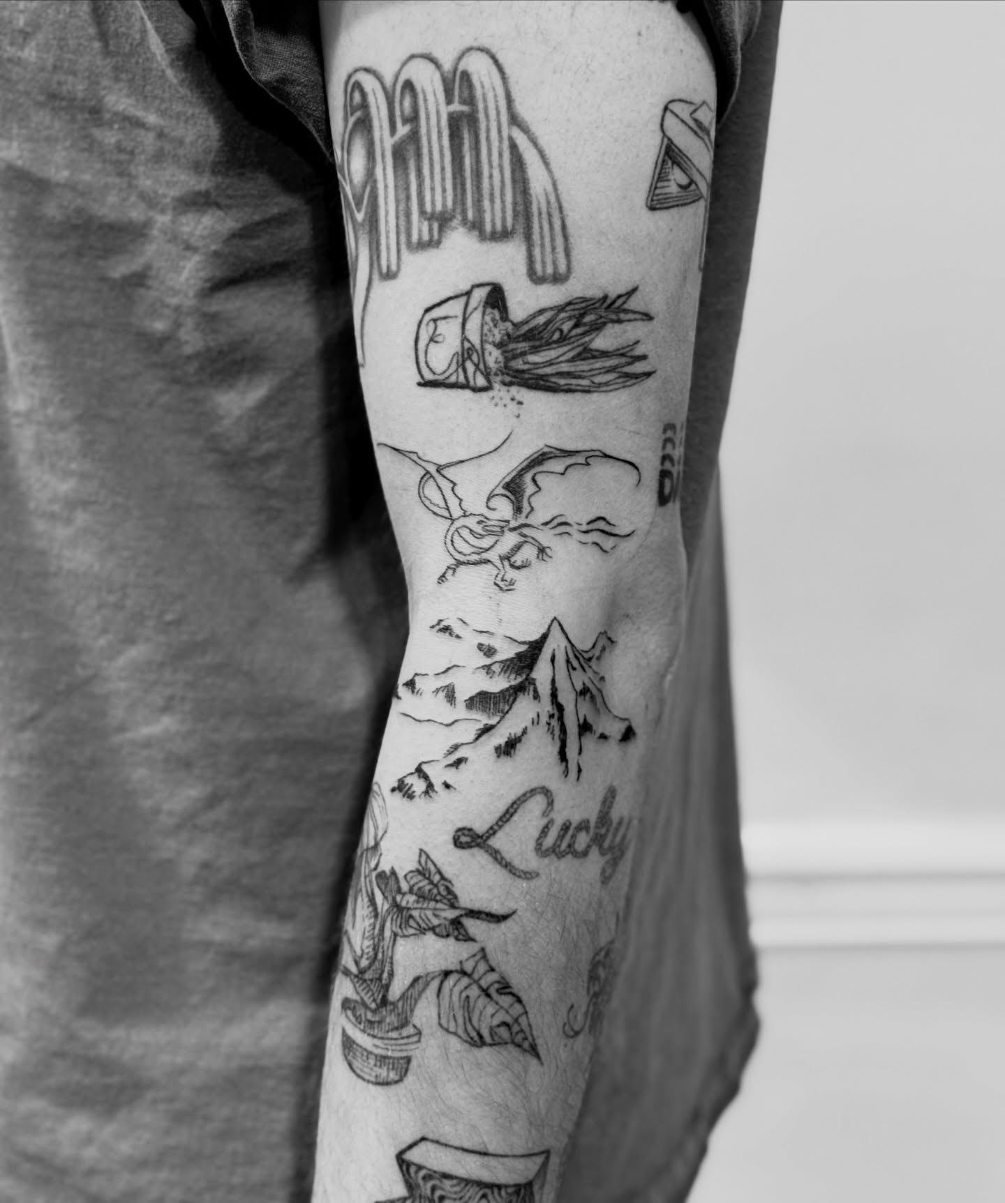 Mountain and clouds black and grey tattoo on the forearm by Sarah