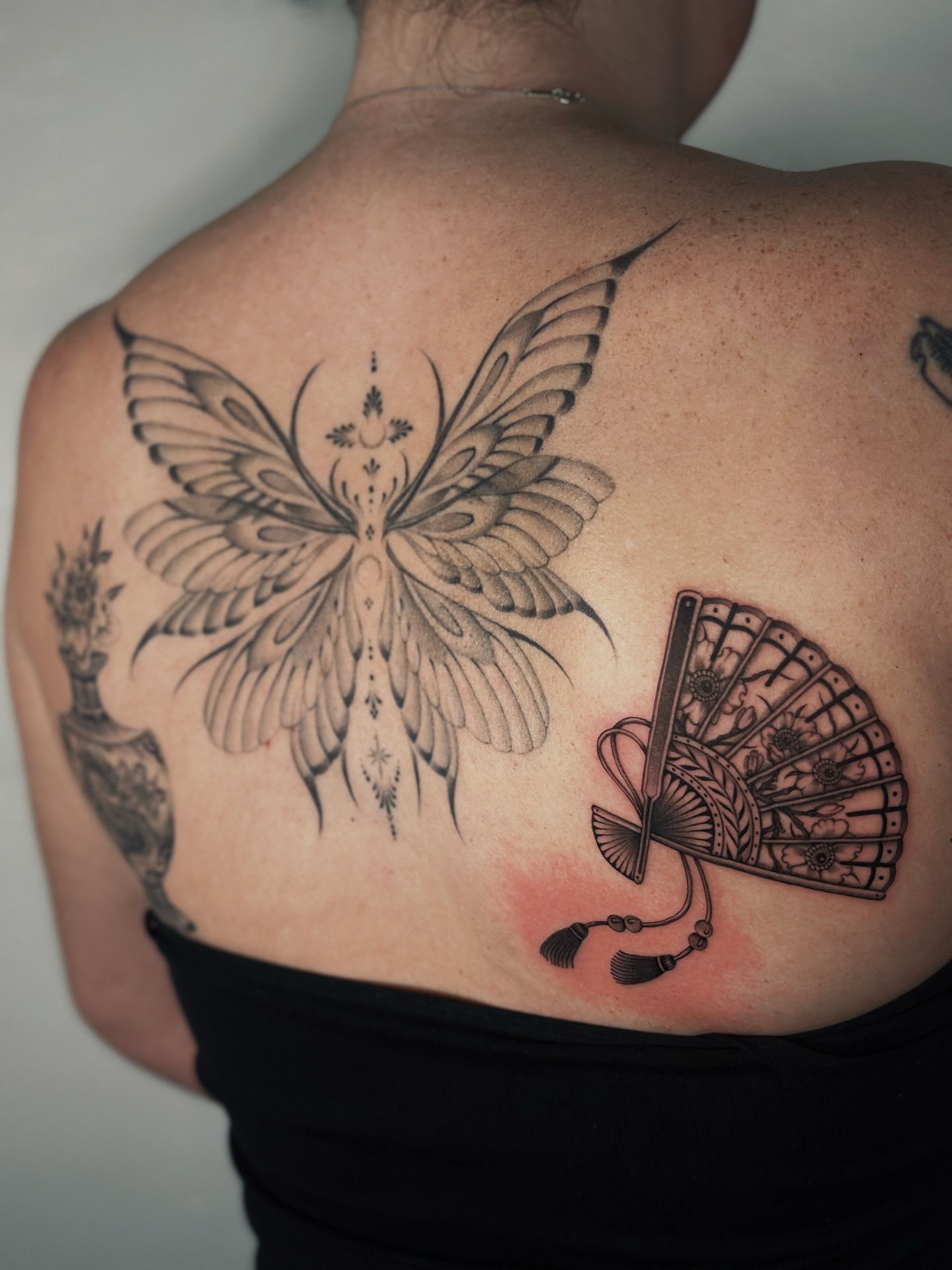 Butterfly and fan geometric tattoo on the back by Lauryn Jenesis