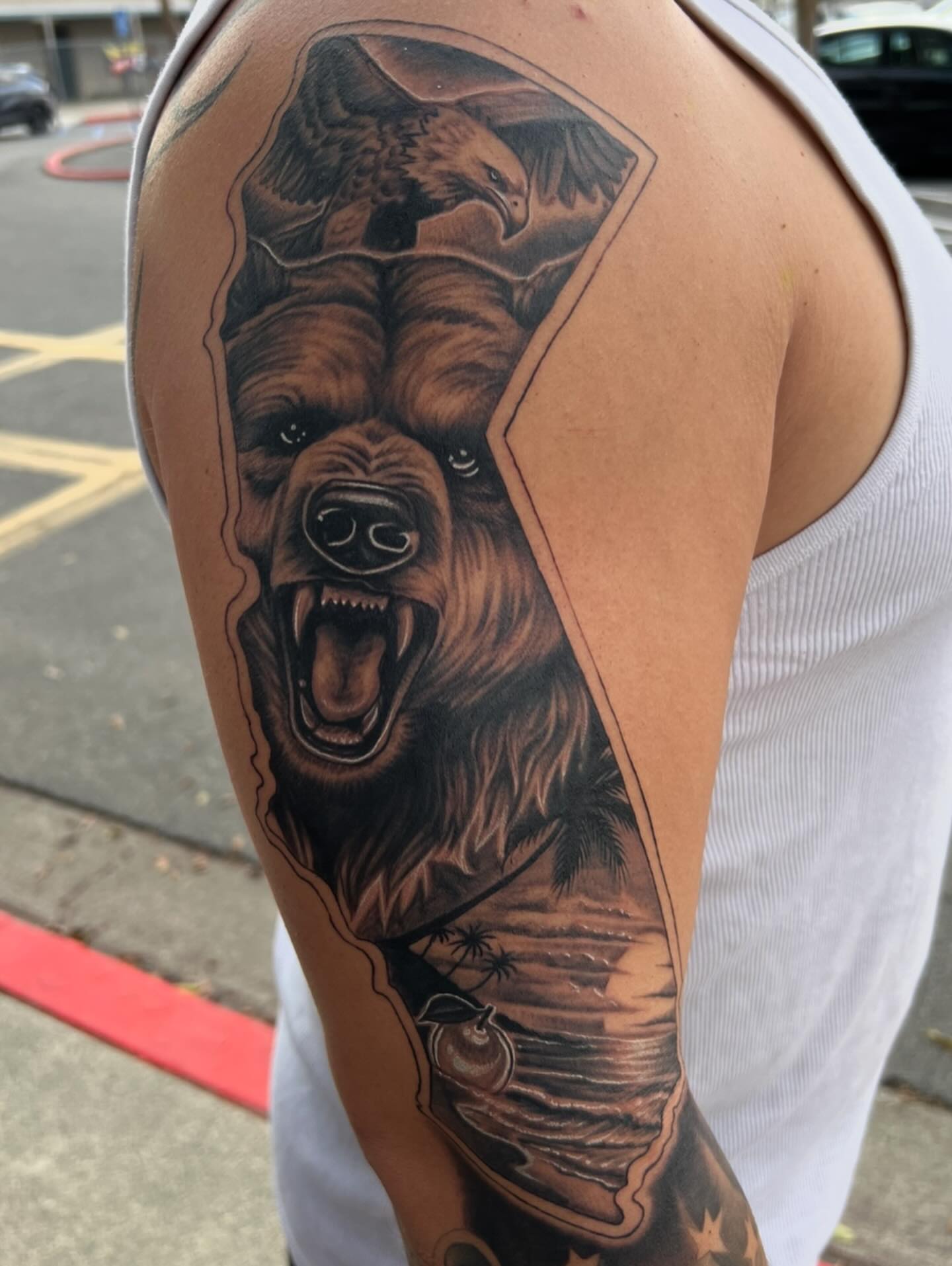 Roaring bear realism tattoo on the upper arm by Niz Carrillo