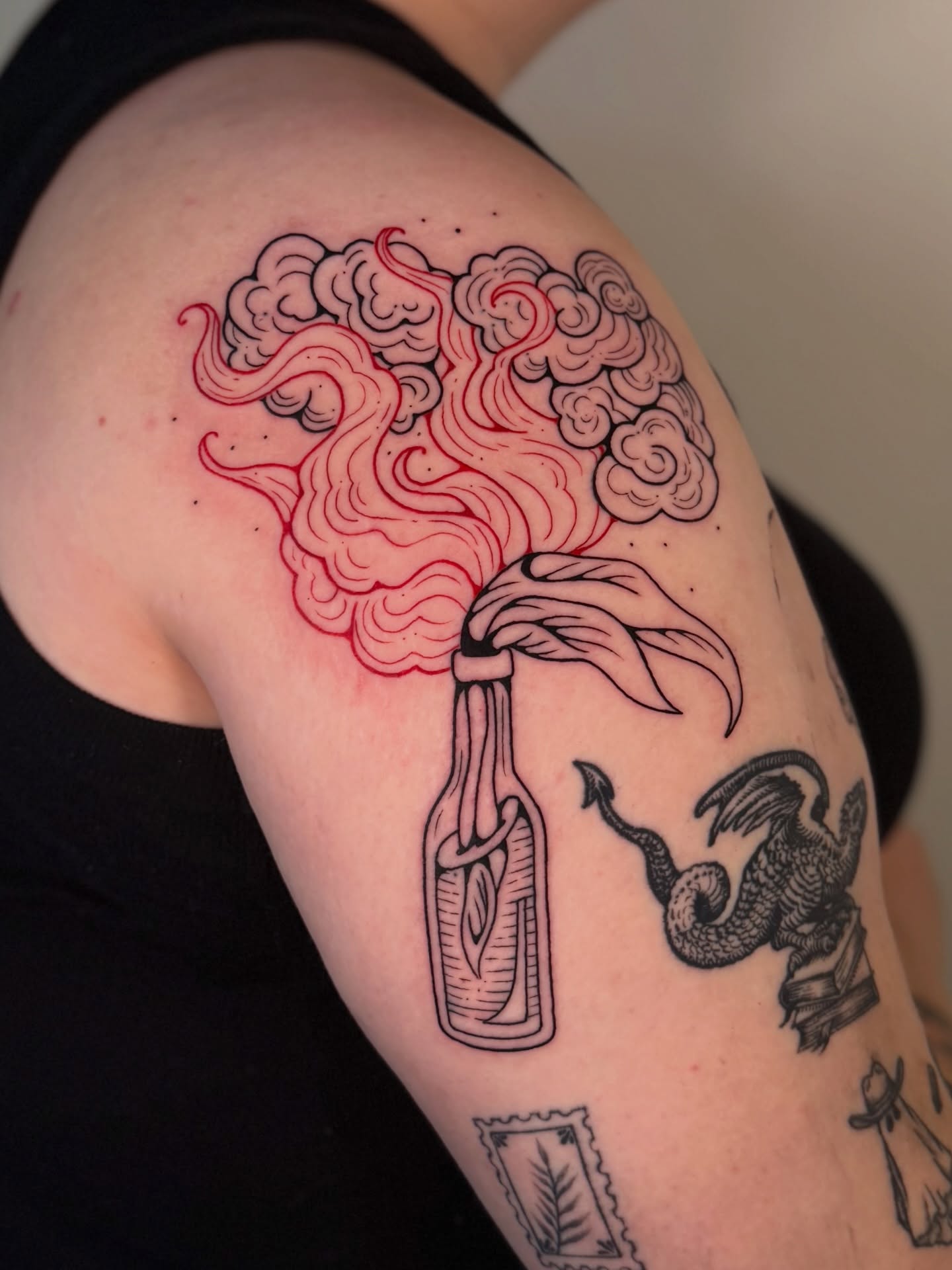 Smoke and bottle neo-traditional tattoo on the shoulder by Kail