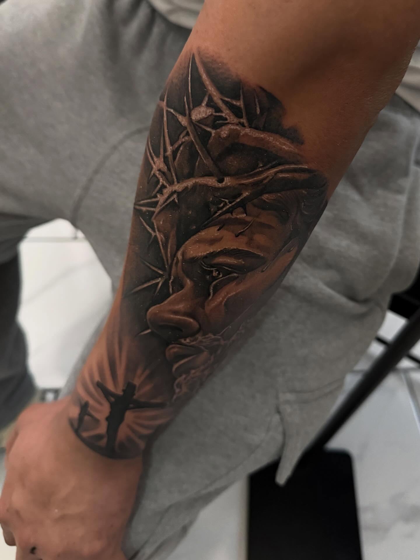 Man's face realism tattoo on the forearm by Adrian gonzalez...