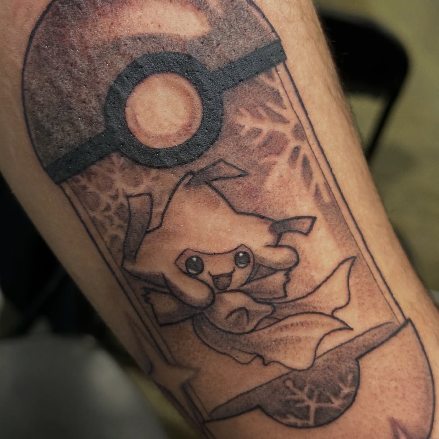 Pikachu in a Poké Ball black and grey tattoo on the forearm by Mia Layne 🤎