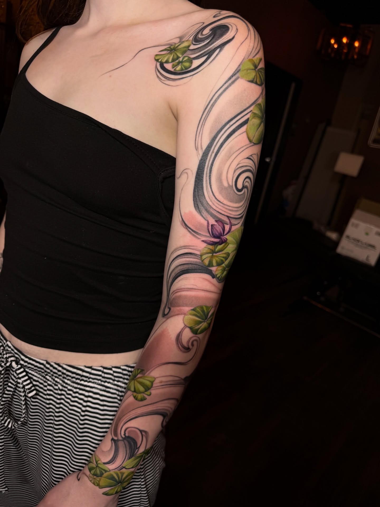 Water lilies new school tattoo on the upper arm by Jevon Glasco Tattoos