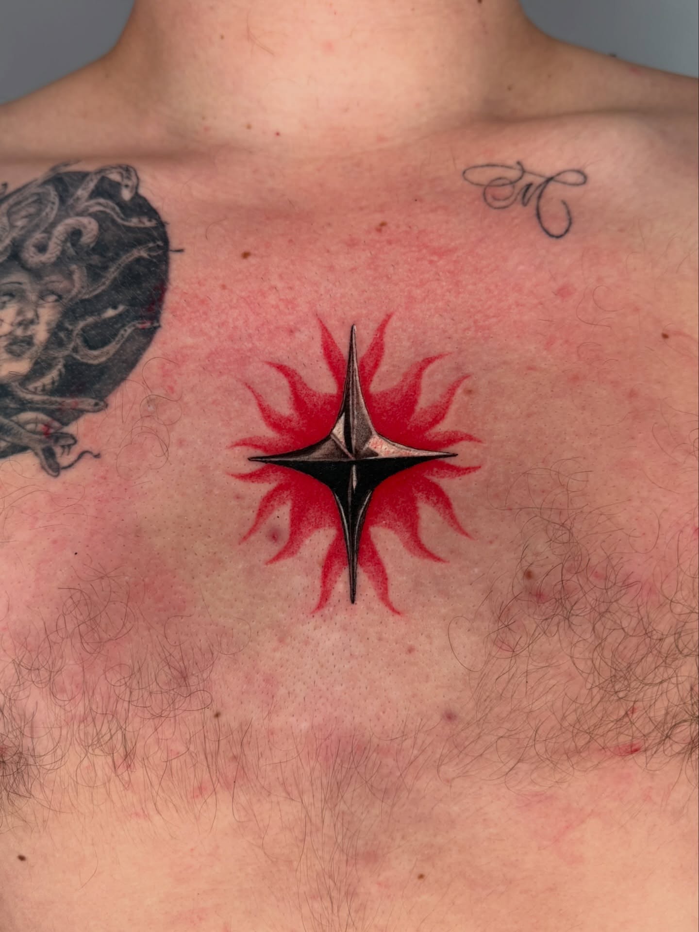 Geometric starburst geometric tattoo on the chest by Jerm Lewis