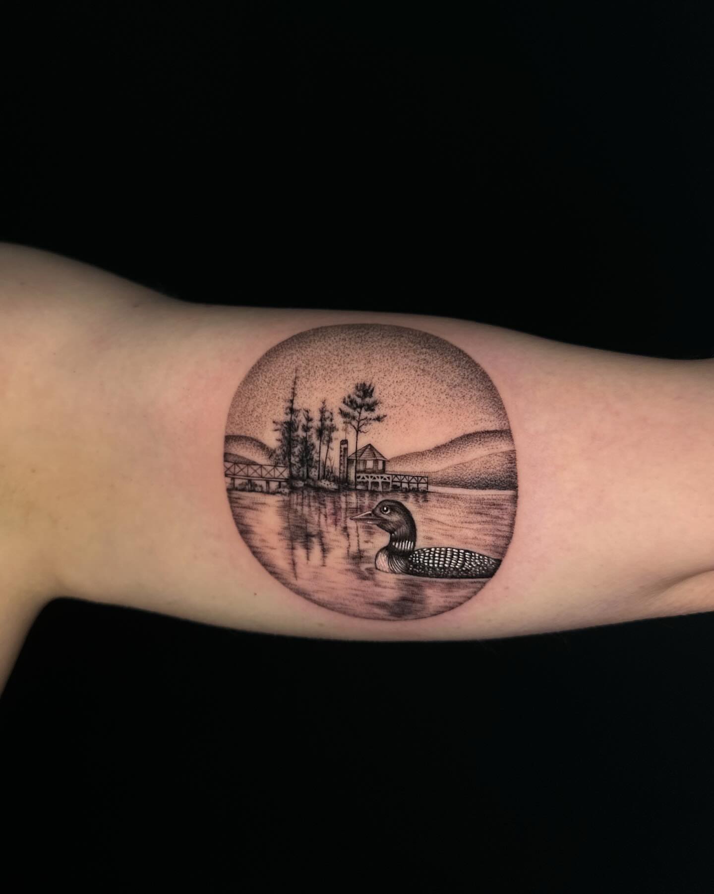 Loon and lake scene dotwork tattoo on the forearm by Jhonny David lay