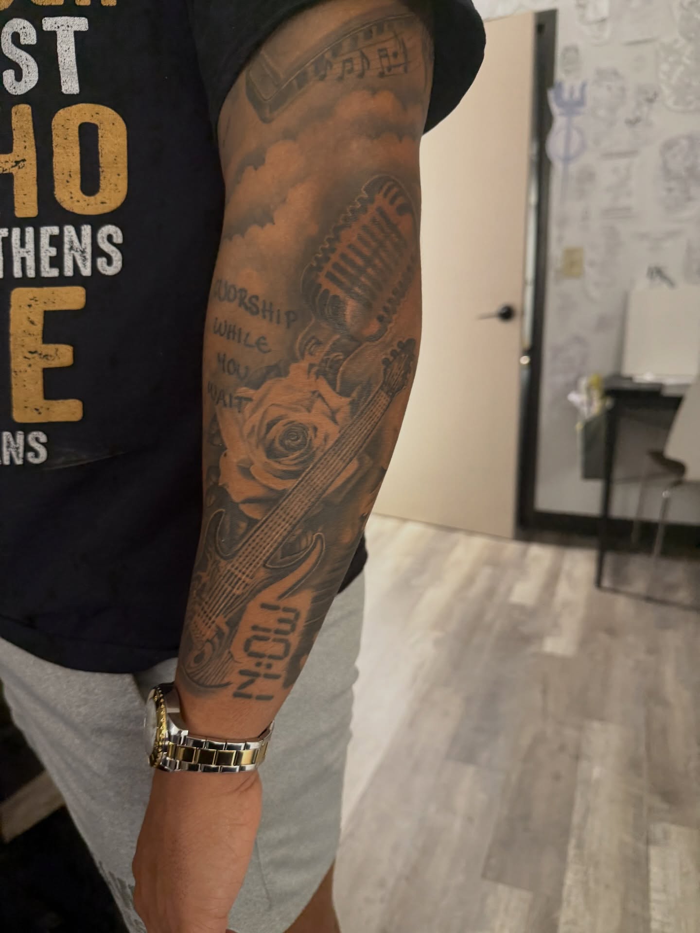 Guitar and rose black and grey tattoo on the forearm by Atlanta Tattoo Artist