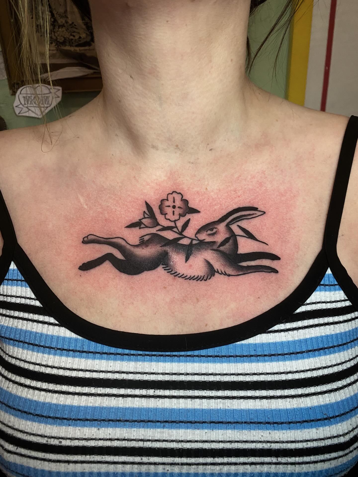 Hopping rabbit black and grey tattoo on the chest by Jaclin Grace Hastings
