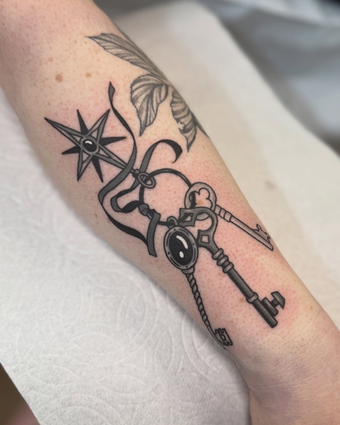 Key and compass black and grey tattoo on the forearm by Nia (Knee-uhh) 🦷