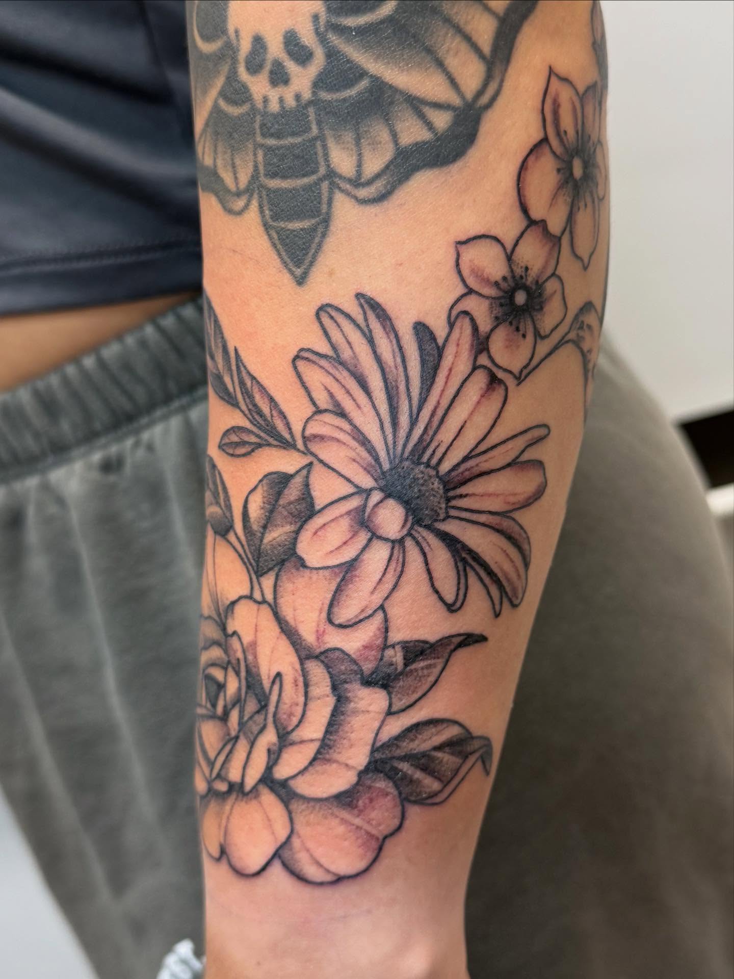 Flowers black and grey tattoo on the forearm by Rigo Vargas