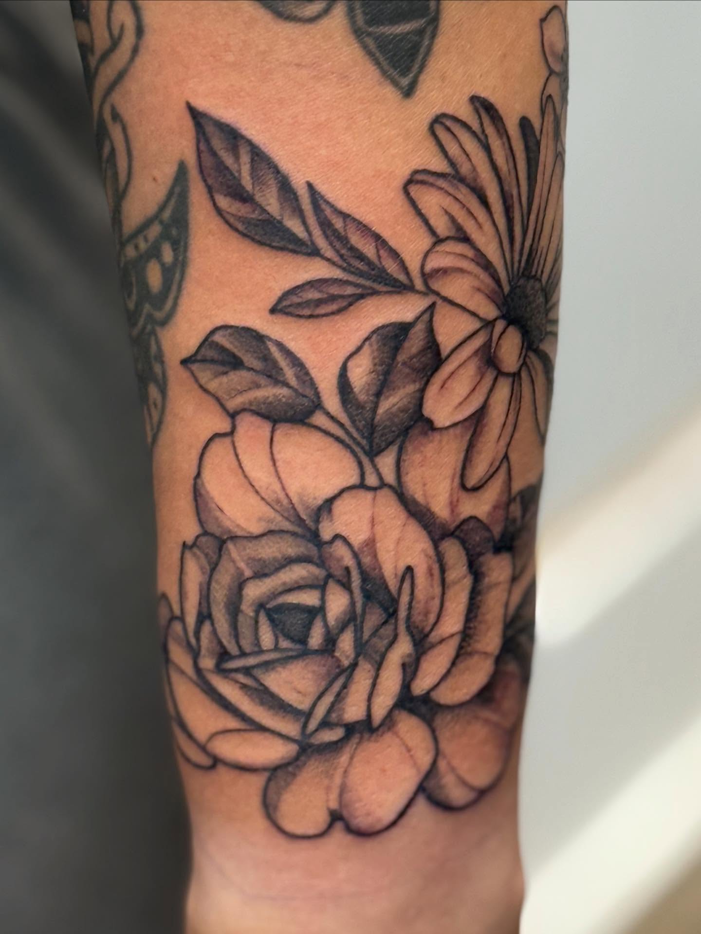 Floral bouquet realism tattoo on the forearm by Rigo Vargas