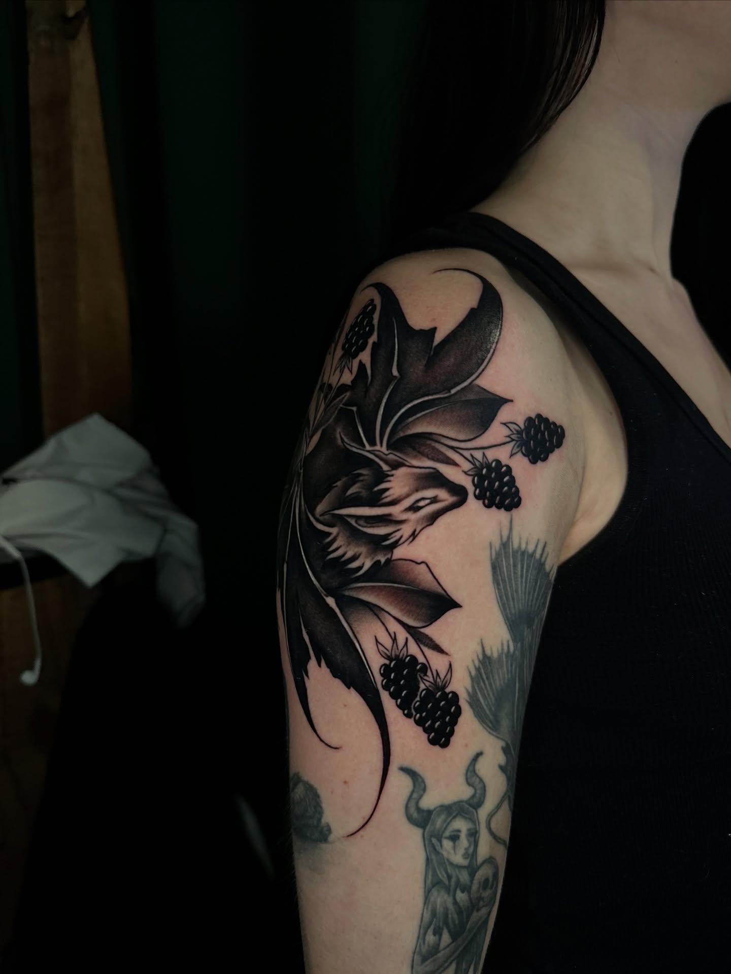 Flower and berries black and grey tattoo on the shoulder by Sam Minneci