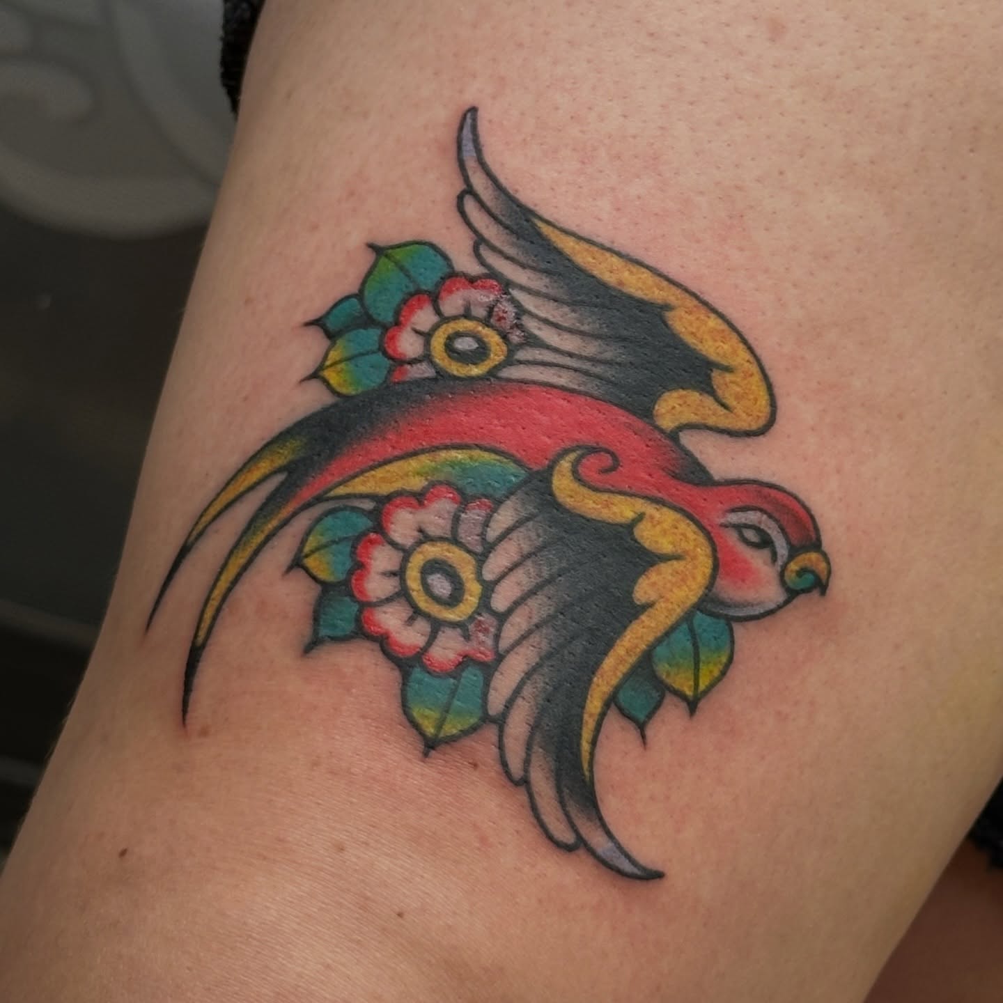 Parrot and flowers American traditional tattoo on the forearm by kira