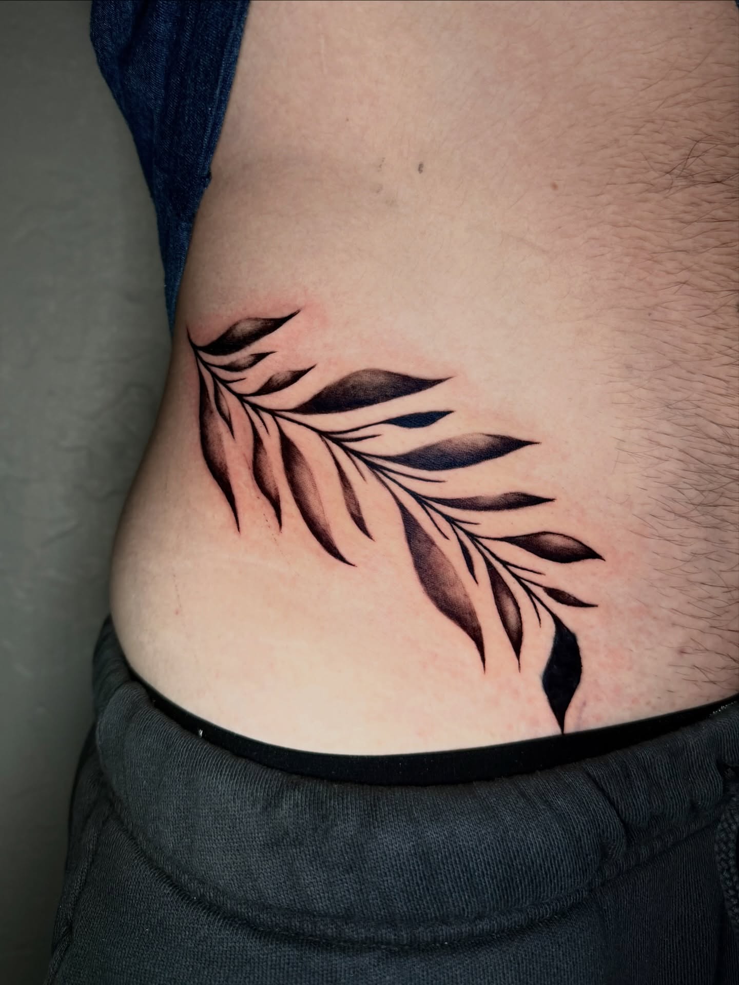 Feather black and grey tattoo on the ribs by jayla pantig