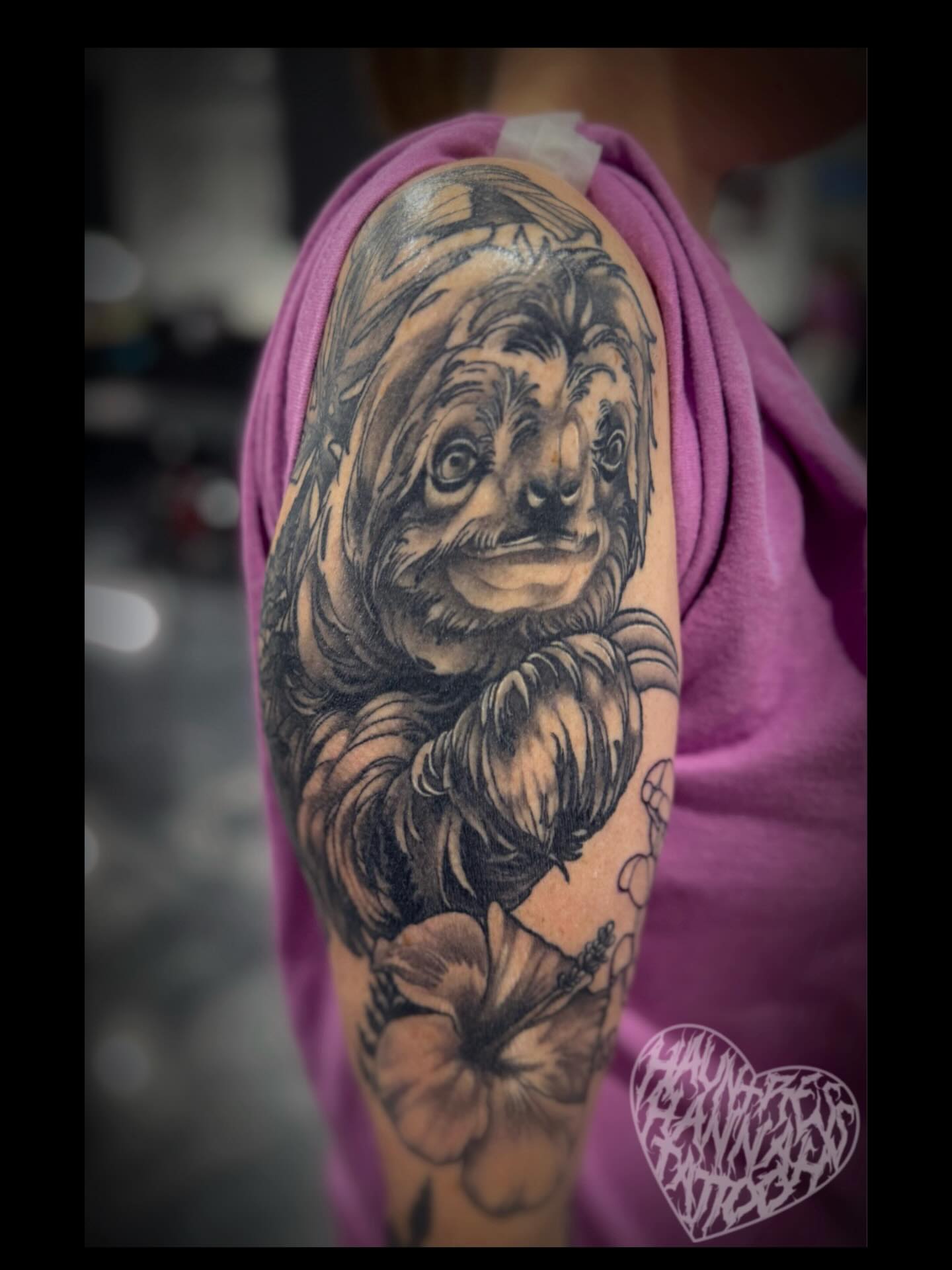 Sloth black and grey tattoo on the upper arm by Hannah Casadonti